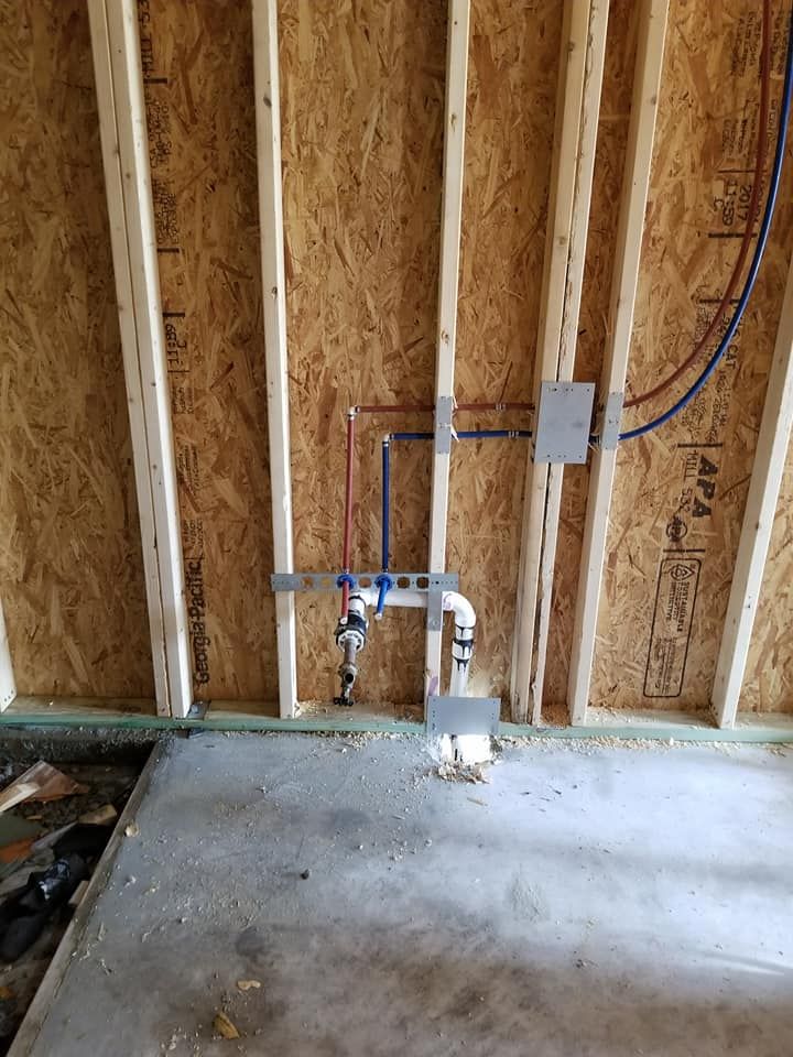 A bathroom with a faucet and pipes in the wall.