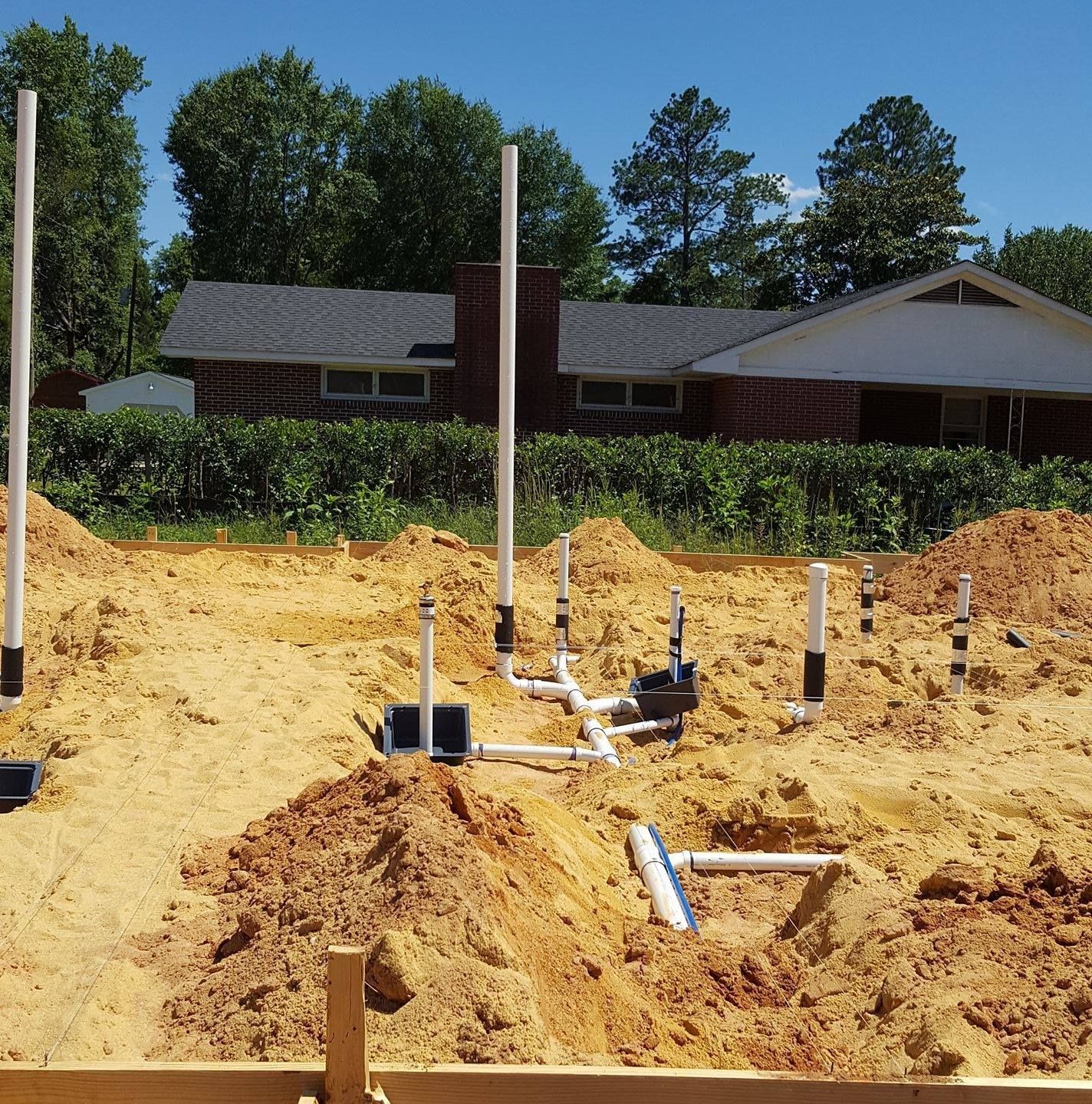 A construction site with a house in the background