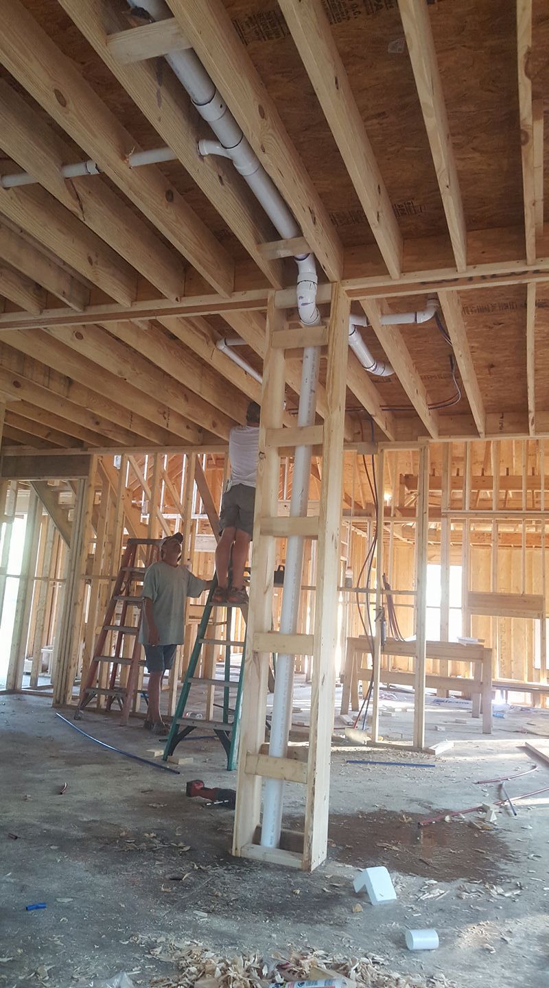 A man is standing on a ladder in a building under construction.