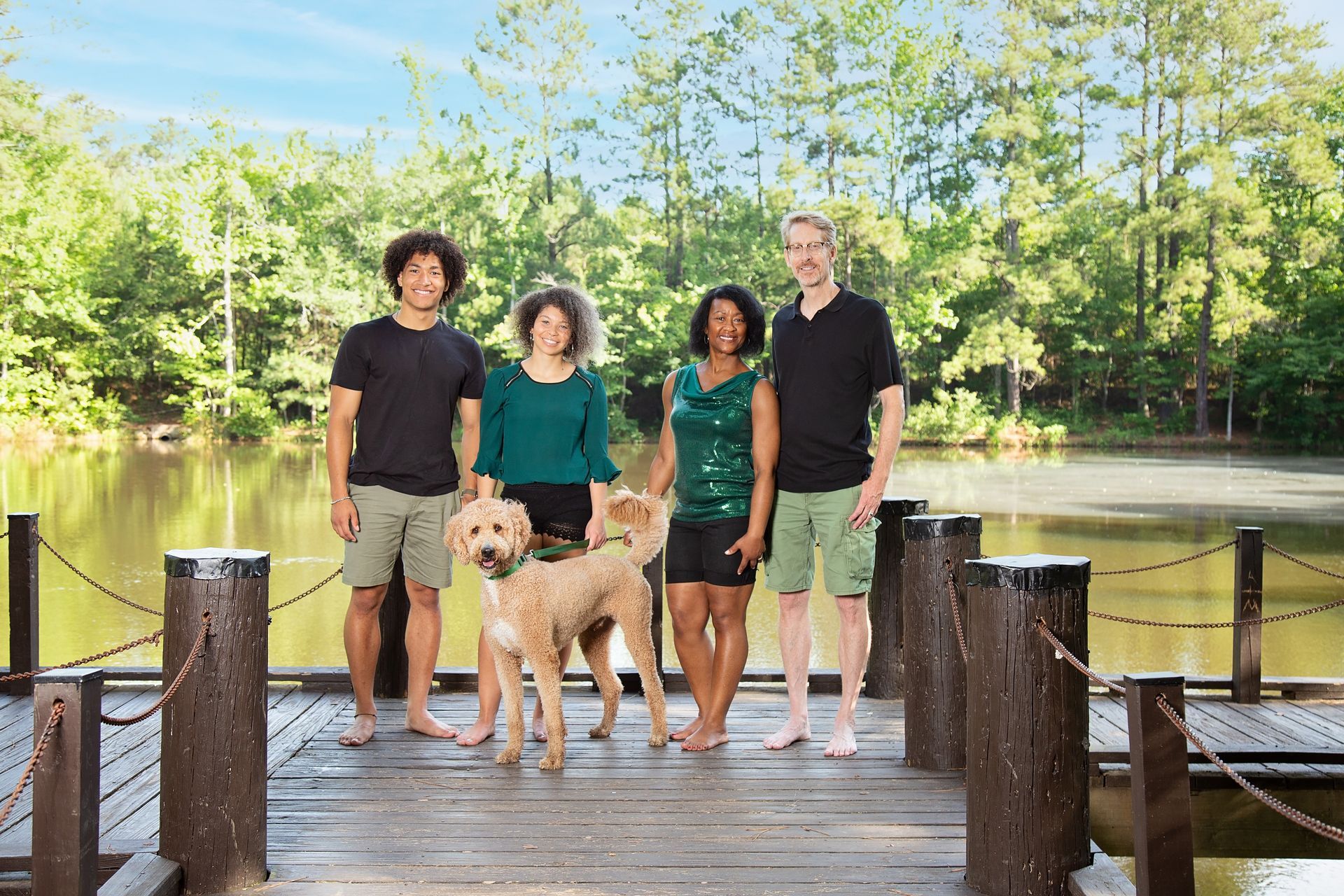 A group of people standing on a dock with a dog.