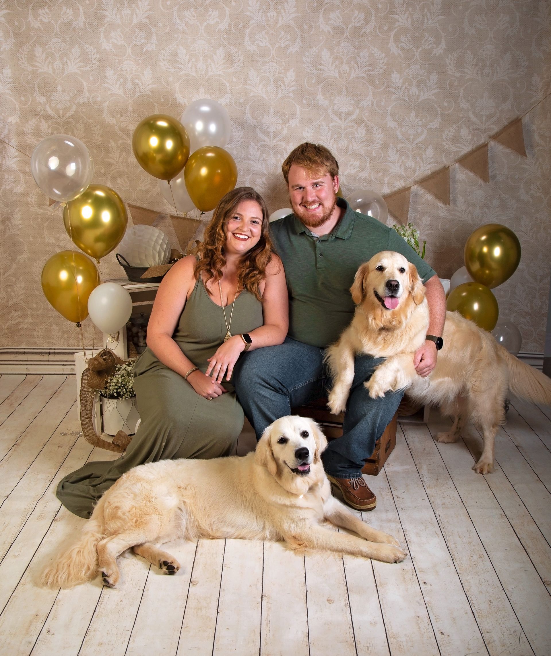 A man and a woman are posing for a picture with two dogs, celebrating their puppy's first birthday .