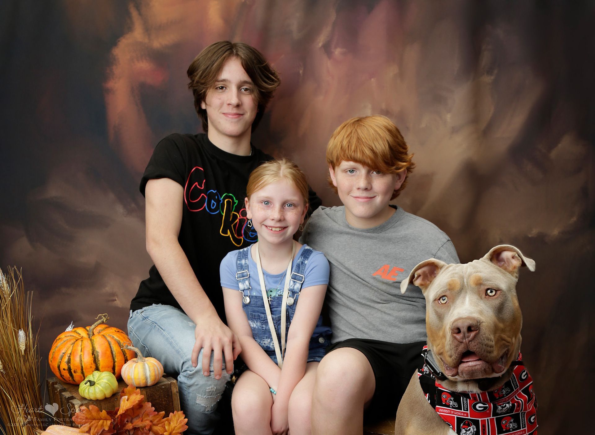 A group of children and a dog are posing for a picture.
