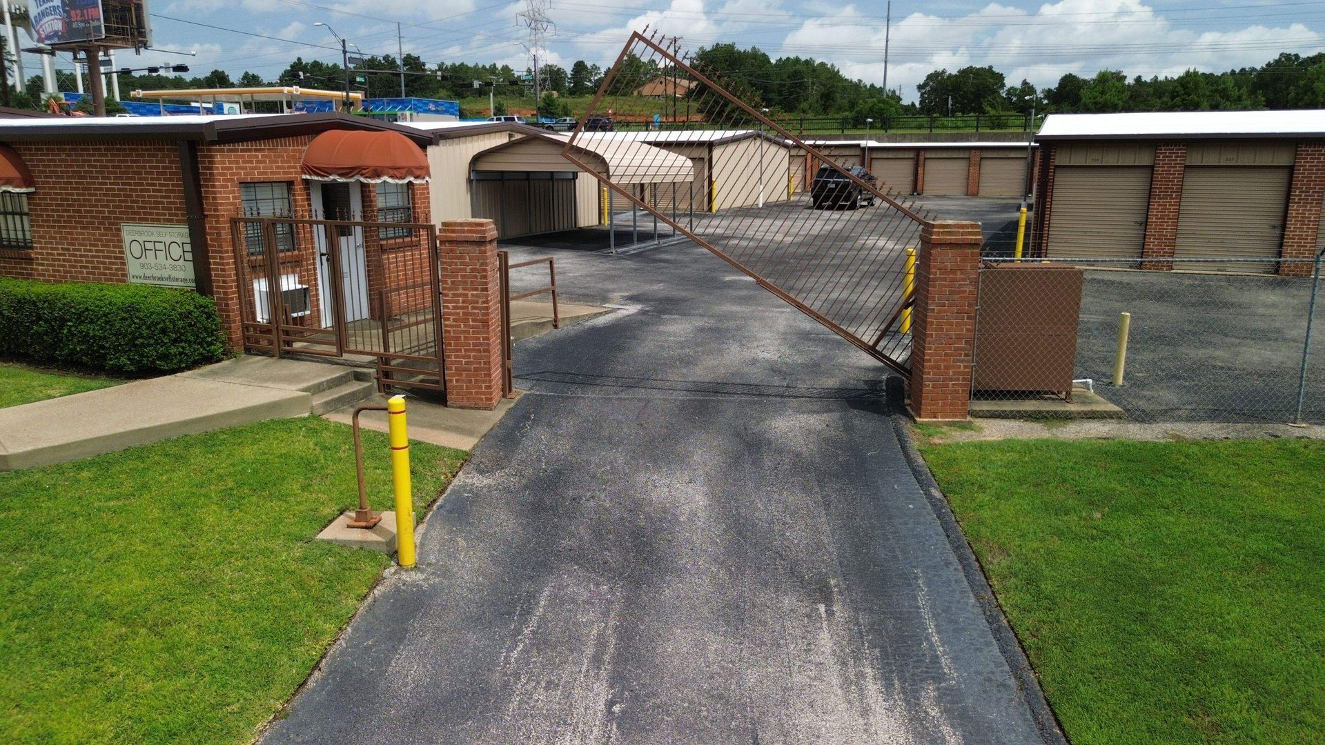 An aerial view of a parking lot with a brick building in the background.