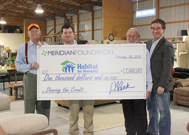 A group of men holding a large check from the meridian foundation