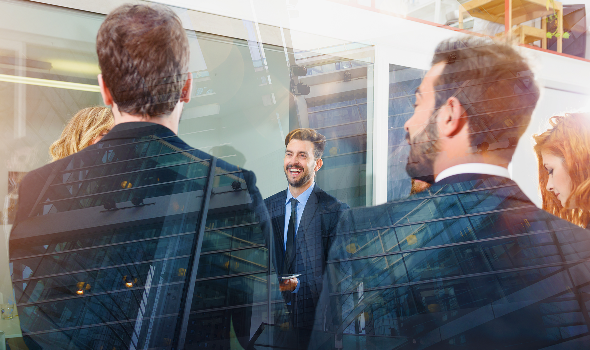 Businesspeople in suits gathered, smiling and talking outside a building. Double exposure with cityscape.