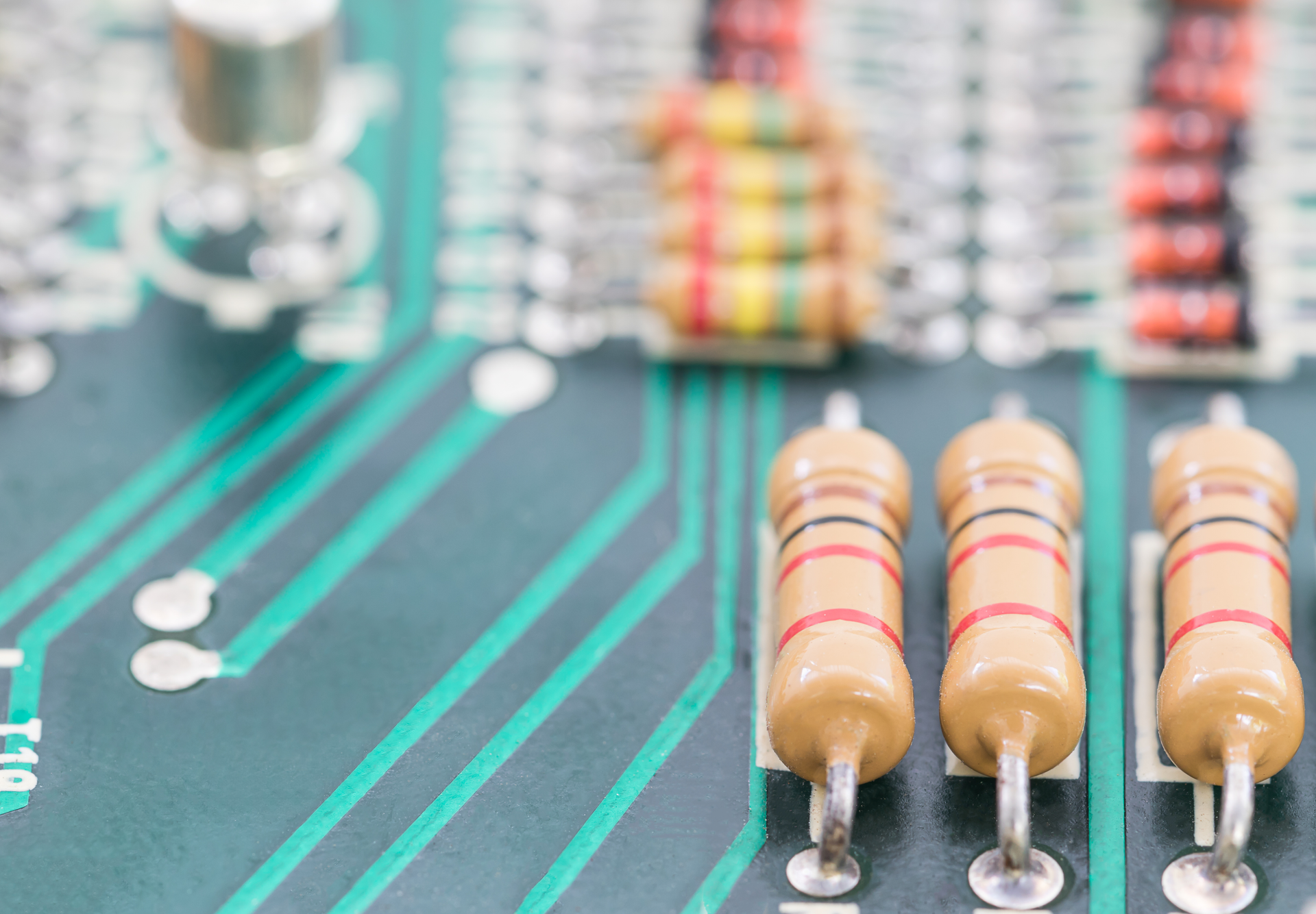 Close-up of a circuit board with multiple resistors and green and white wiring.