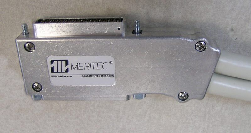 Meritec connector with attached cables, gray metal housing, screws, and company logo.