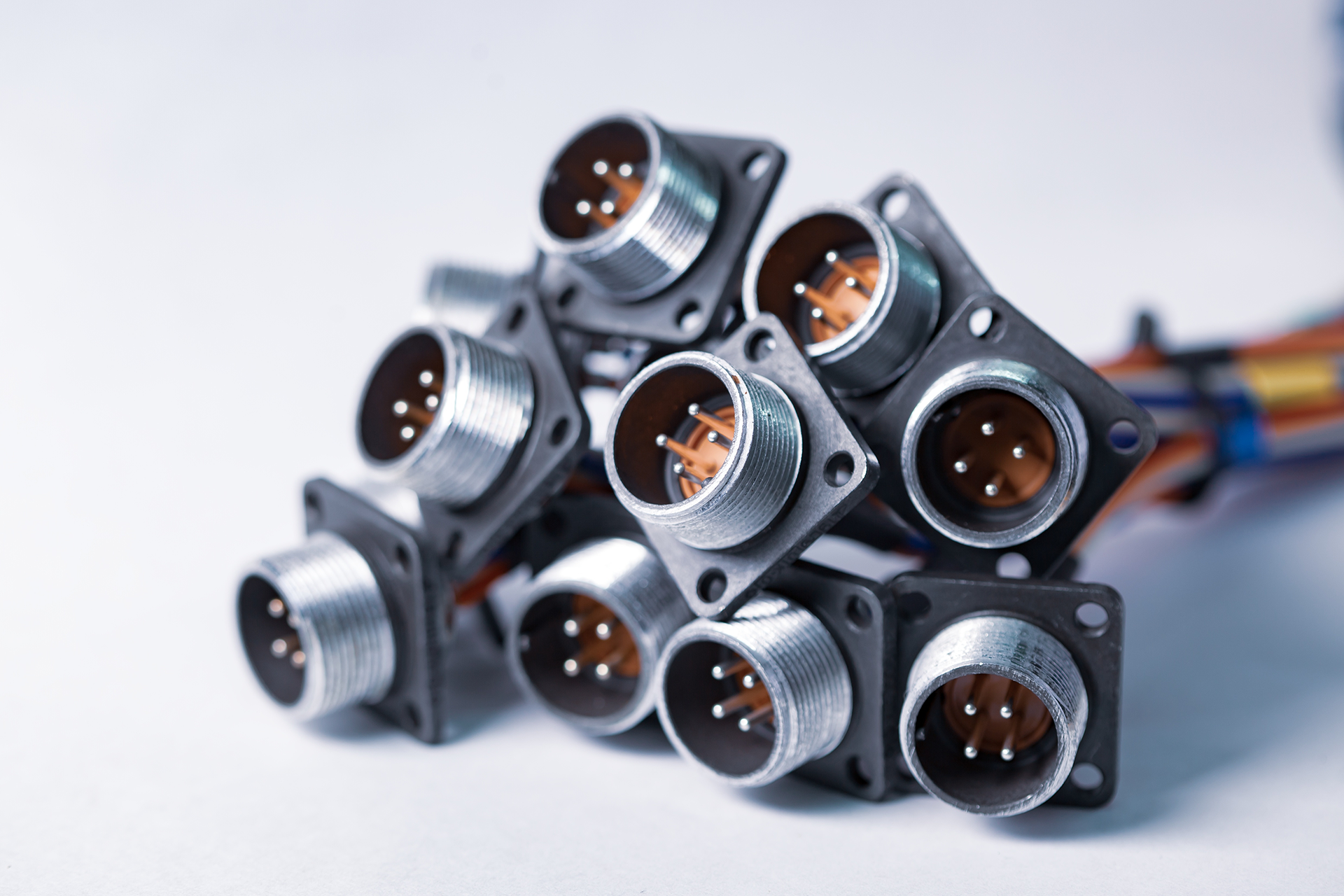 Group of circular electrical connectors with metal housings and pin contacts.