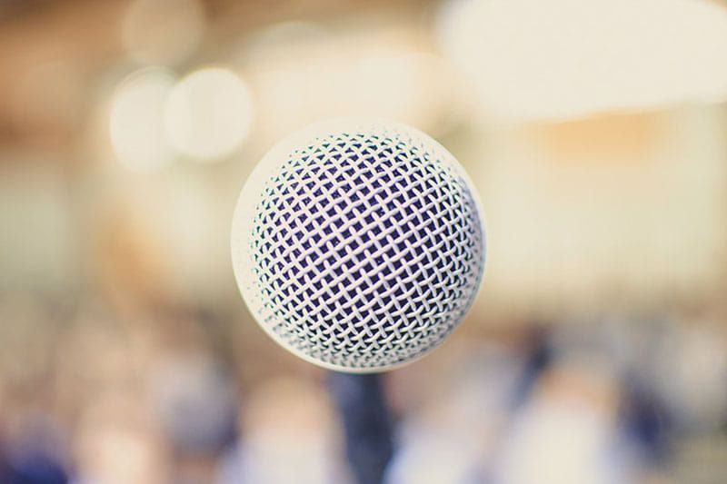 A close up of a microphone with a blurry background.