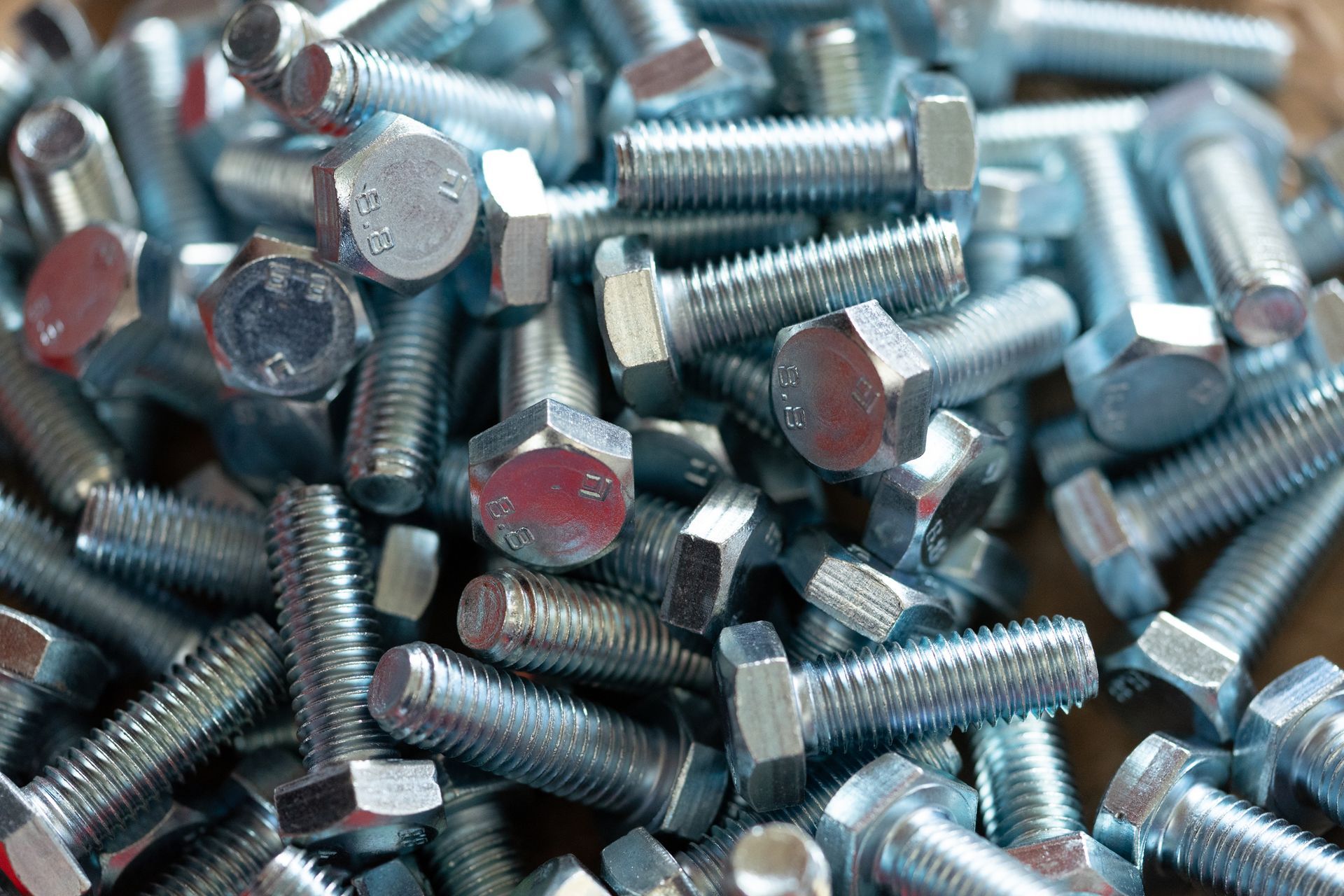 A pile of nuts and bolts on a wooden table.