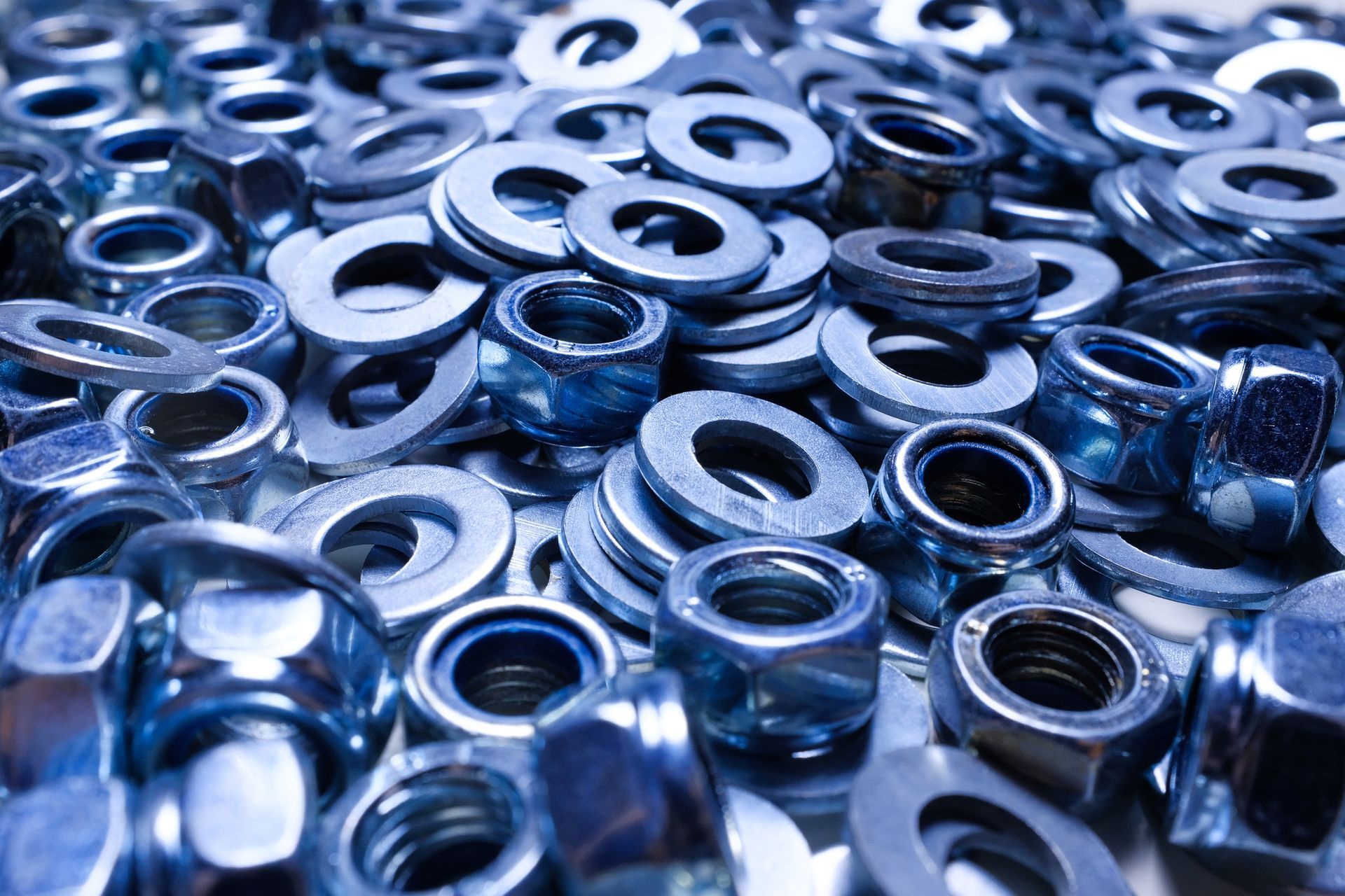 A pile of nuts and washers on a table.