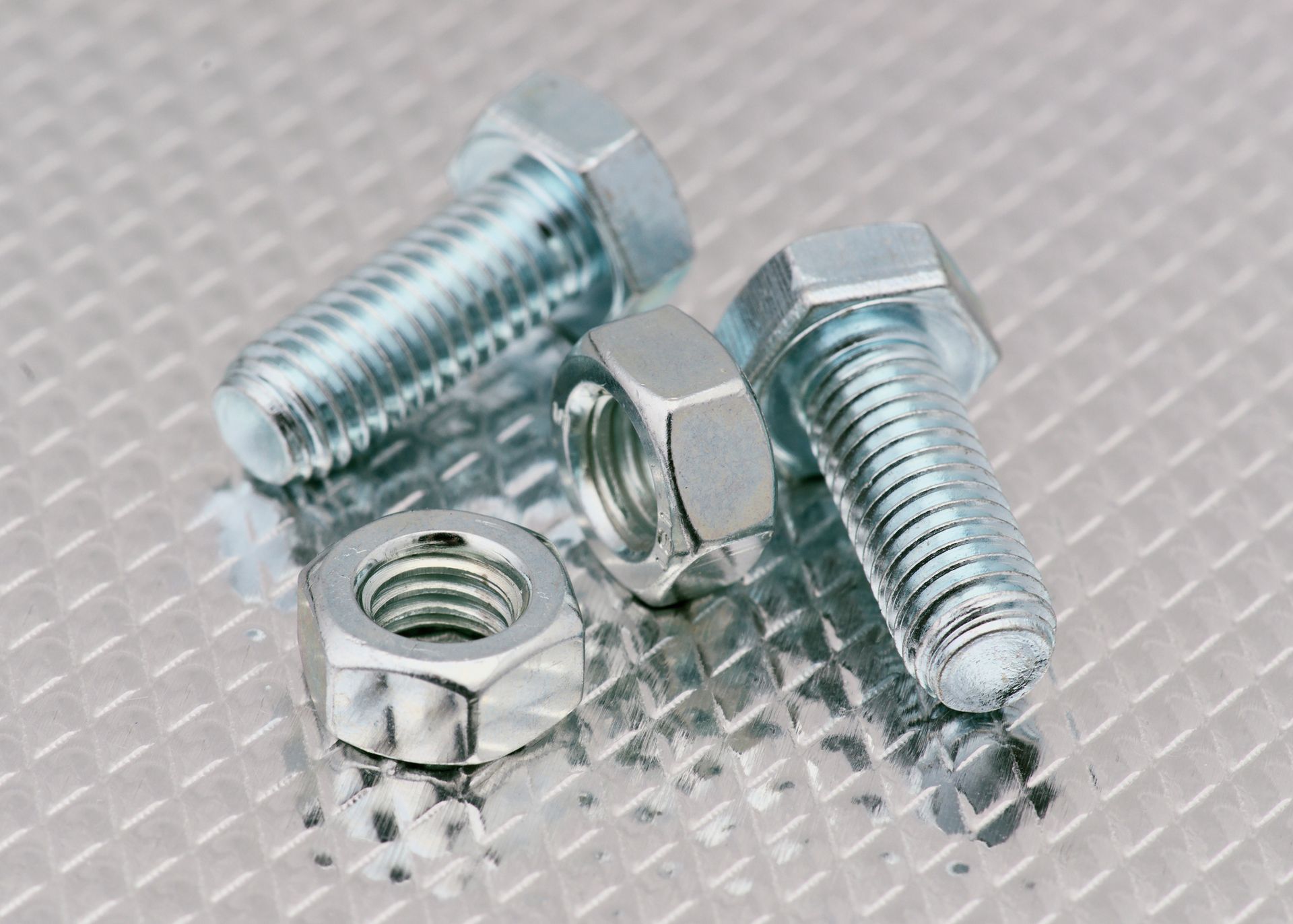 A close up of nuts and bolts on a metal surface.