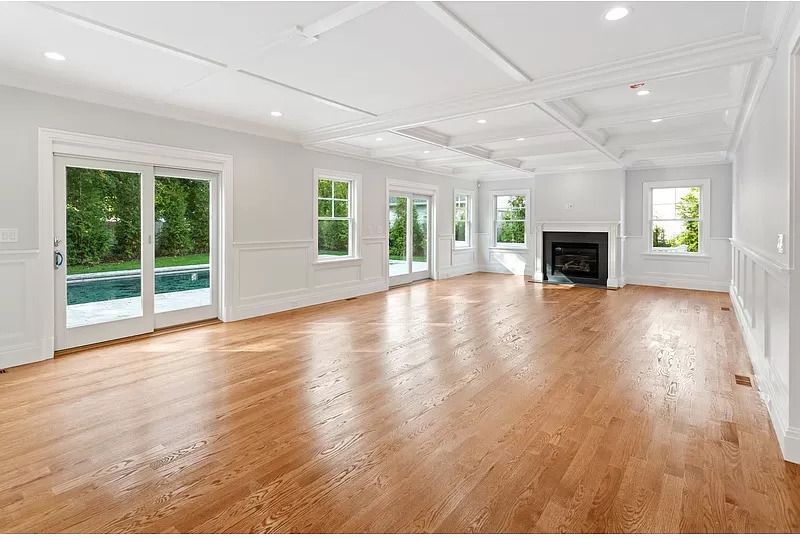 A large empty living room with hardwood floors and a fireplace.