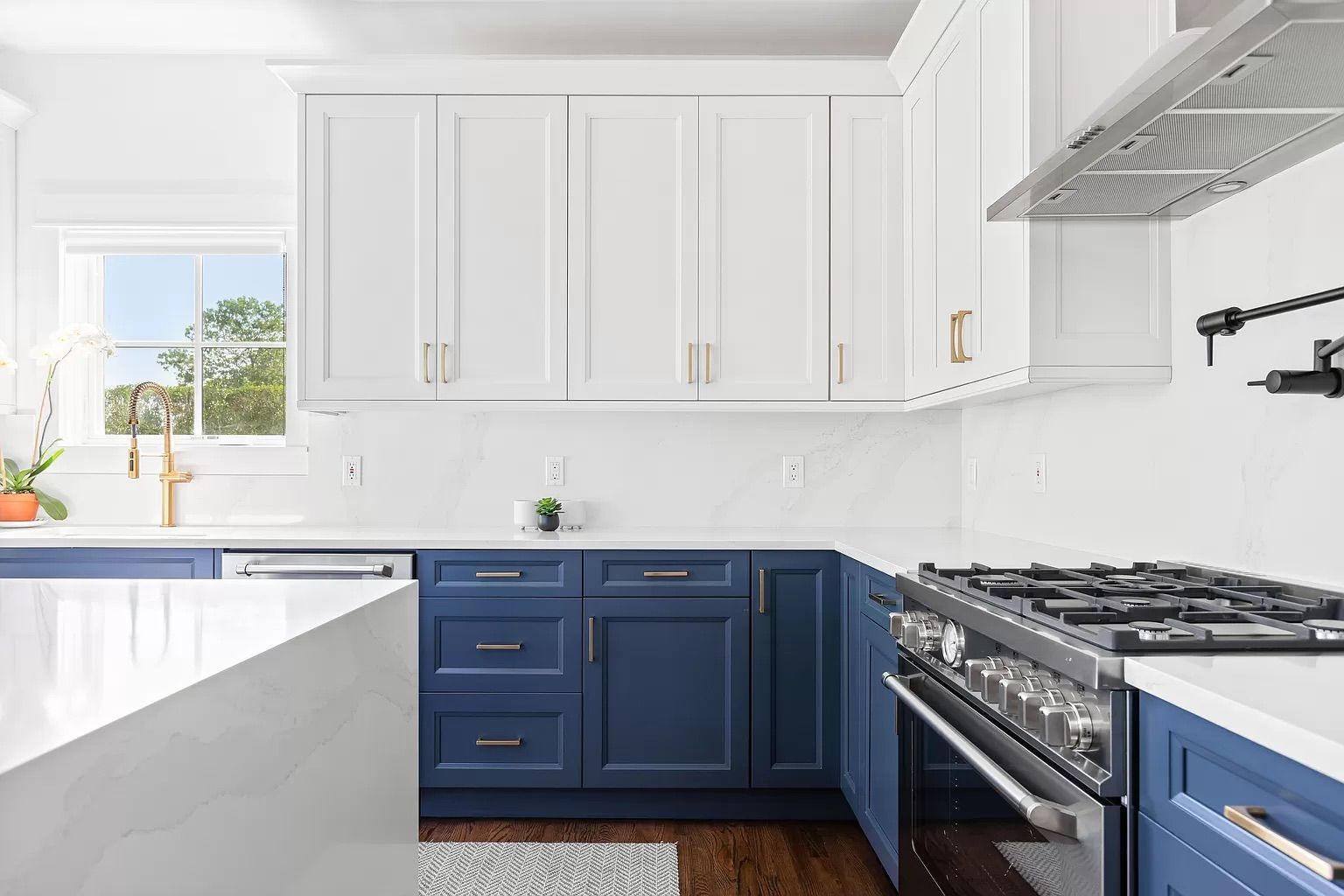 A kitchen with blue cabinets and white counter tops and a stove.