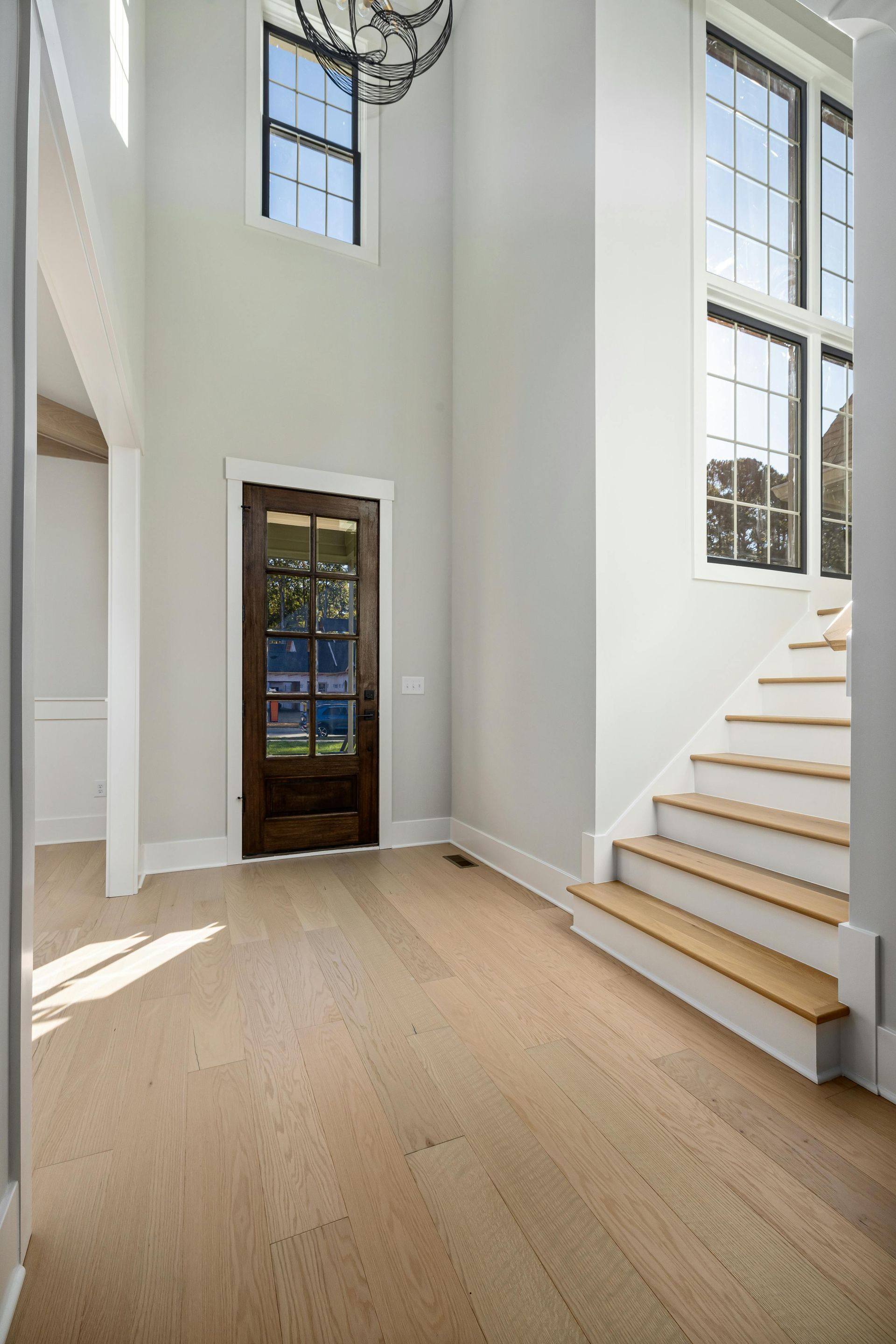 A hallway with stairs and a door in a house.