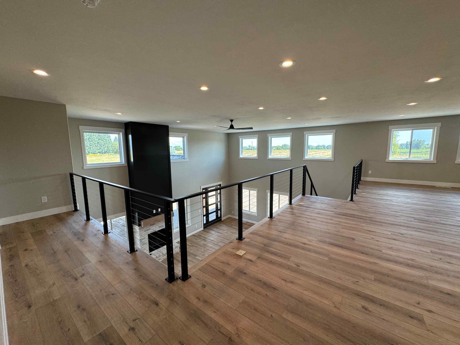 Living room with kitchen in the background. Light wood cabinets, blue walls, a brown couch with pillows, and a dining area.
