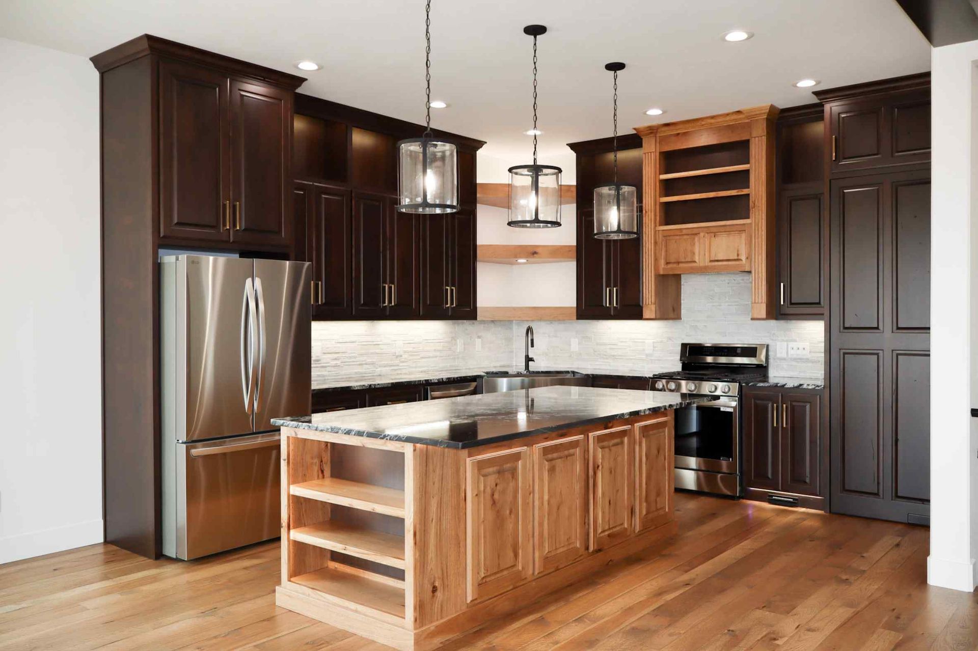 Spacious living room with leather sofas, brick accent wall, and a loft.