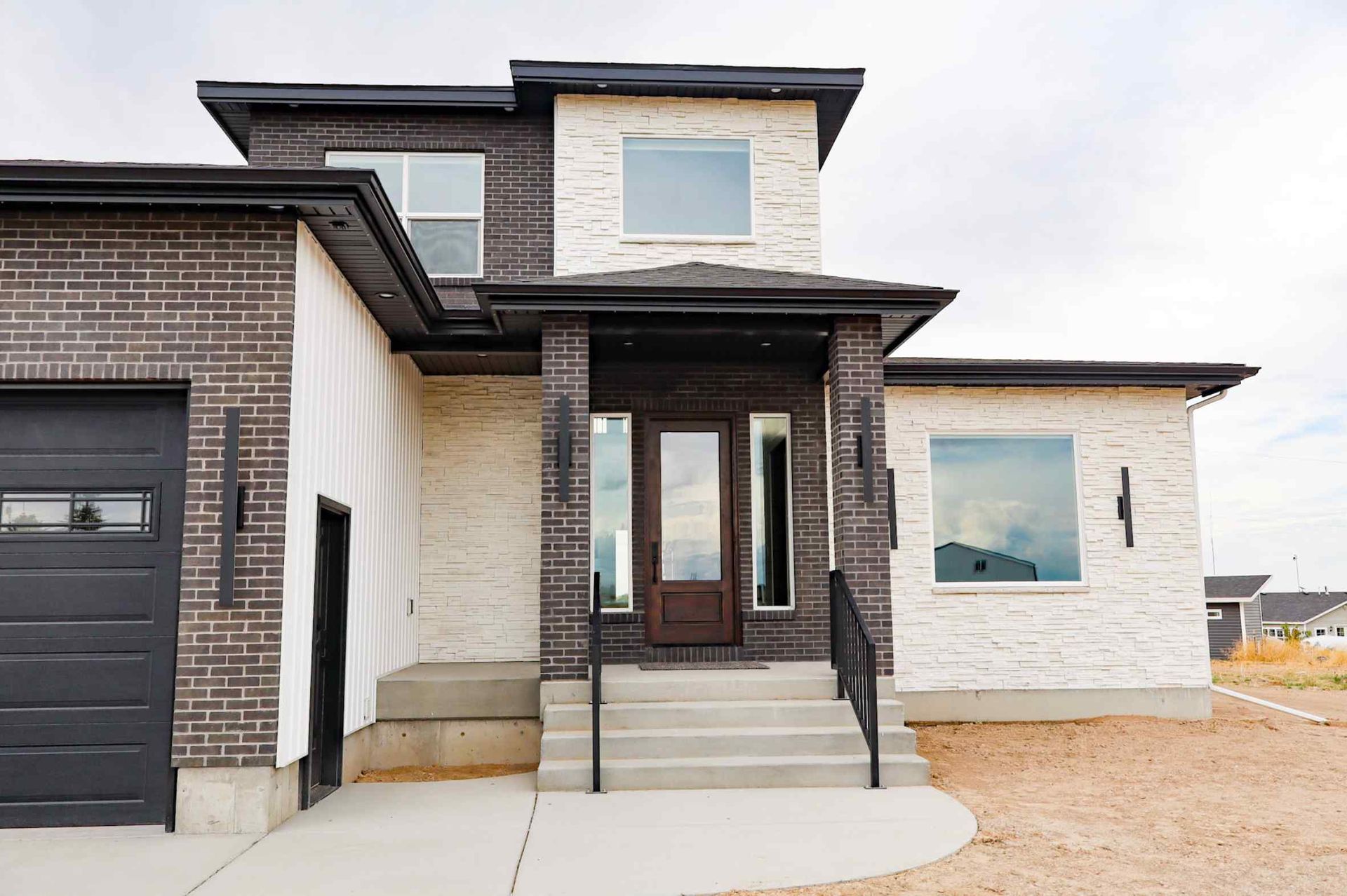 Dining room with table, chairs, stairs, window, hardwood floors, and dog door under stairs.