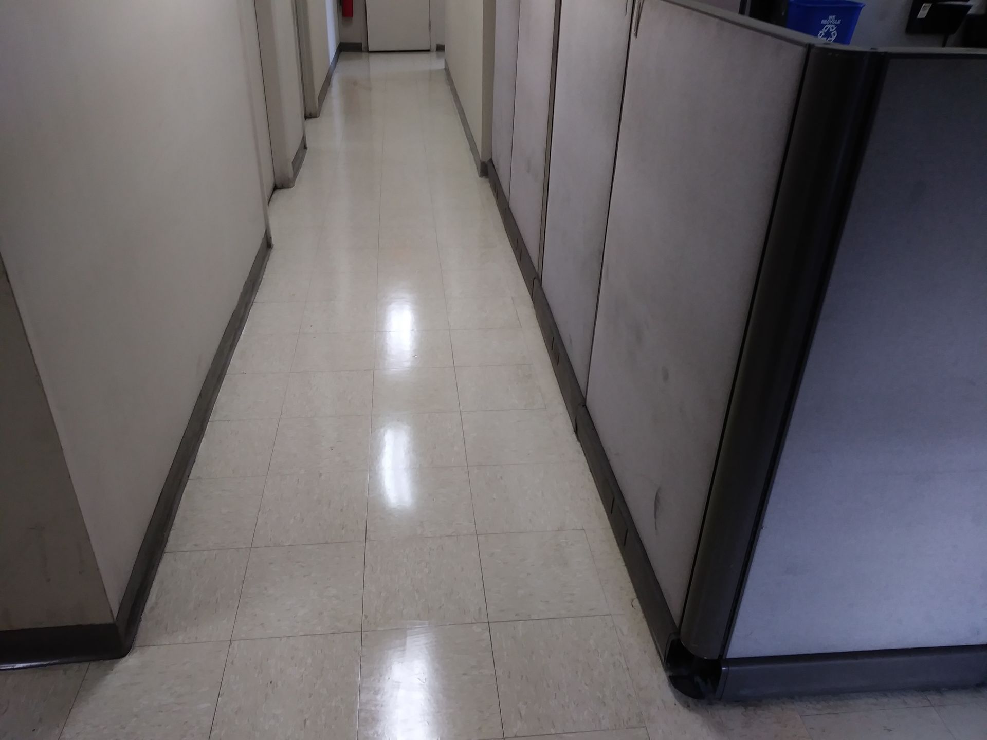 A long hallway with cubicles on both sides of it