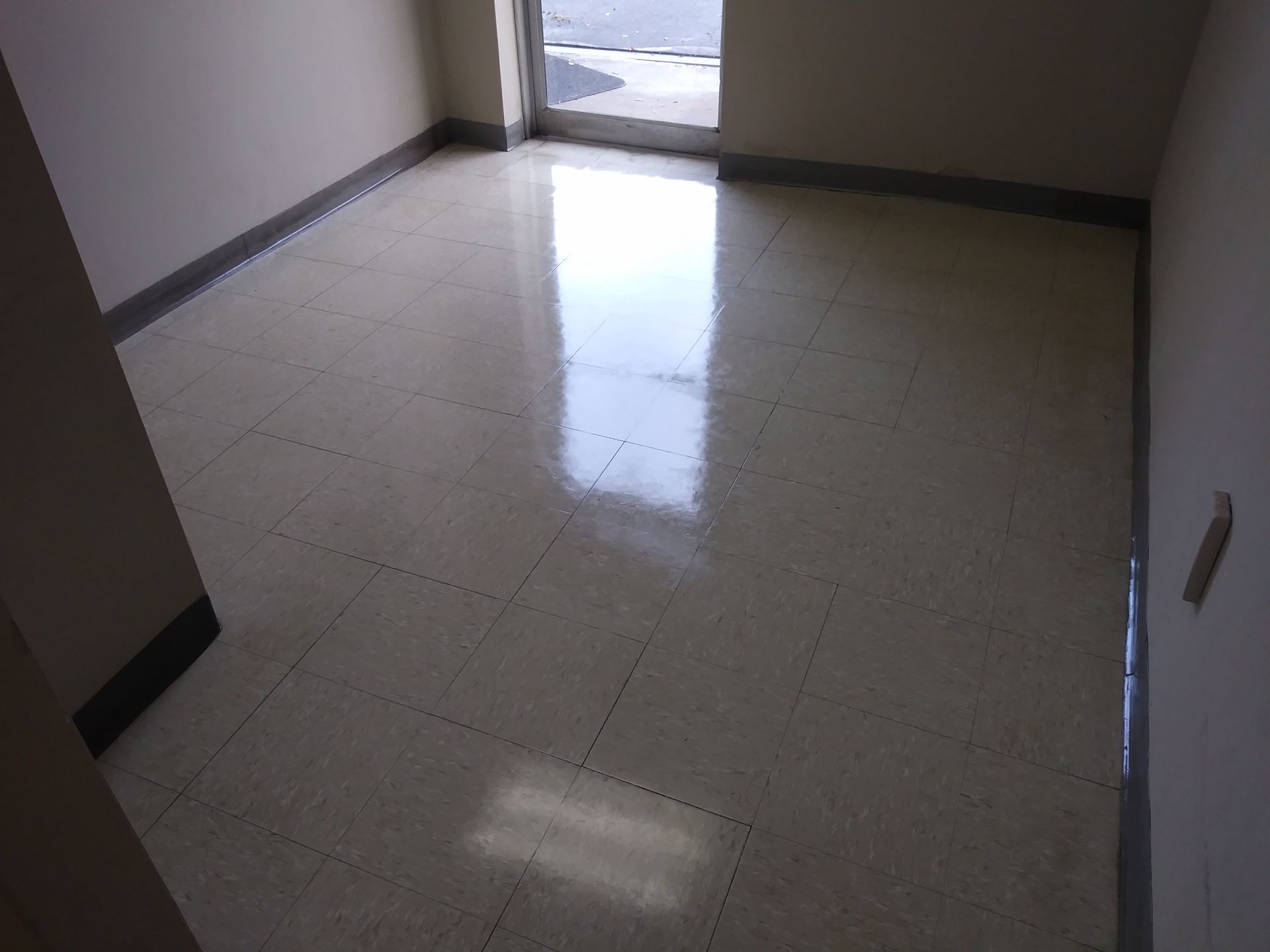 An empty room with a tiled floor and a door