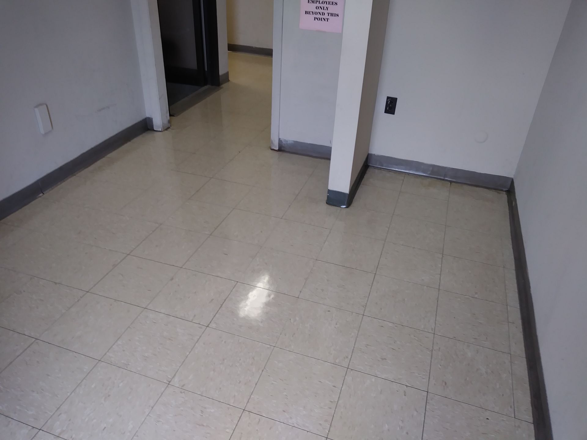 A room with a tiled floor and a sign on the wall