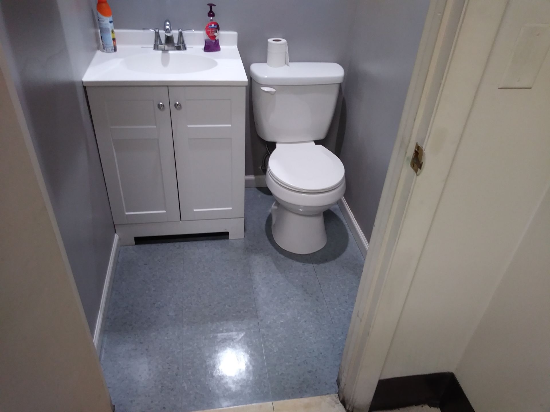 A bathroom with a toilet a sink and a door