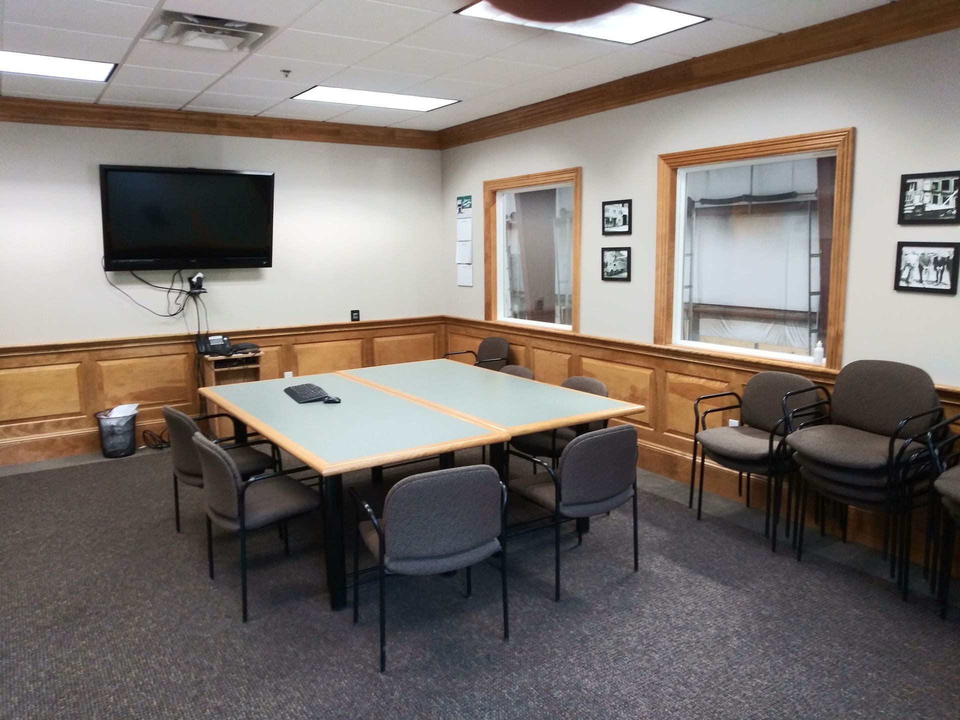 A conference room with a table and chairs and a flat screen tv