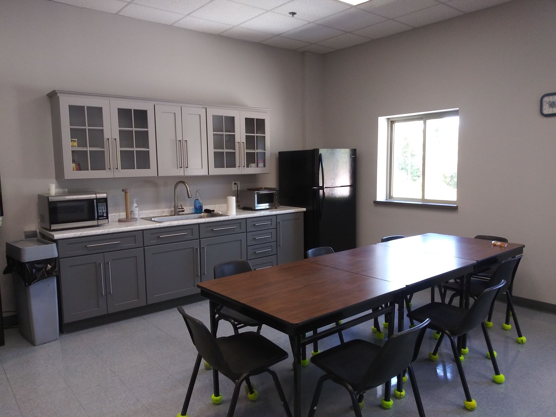 A kitchen with a table and chairs and a refrigerator