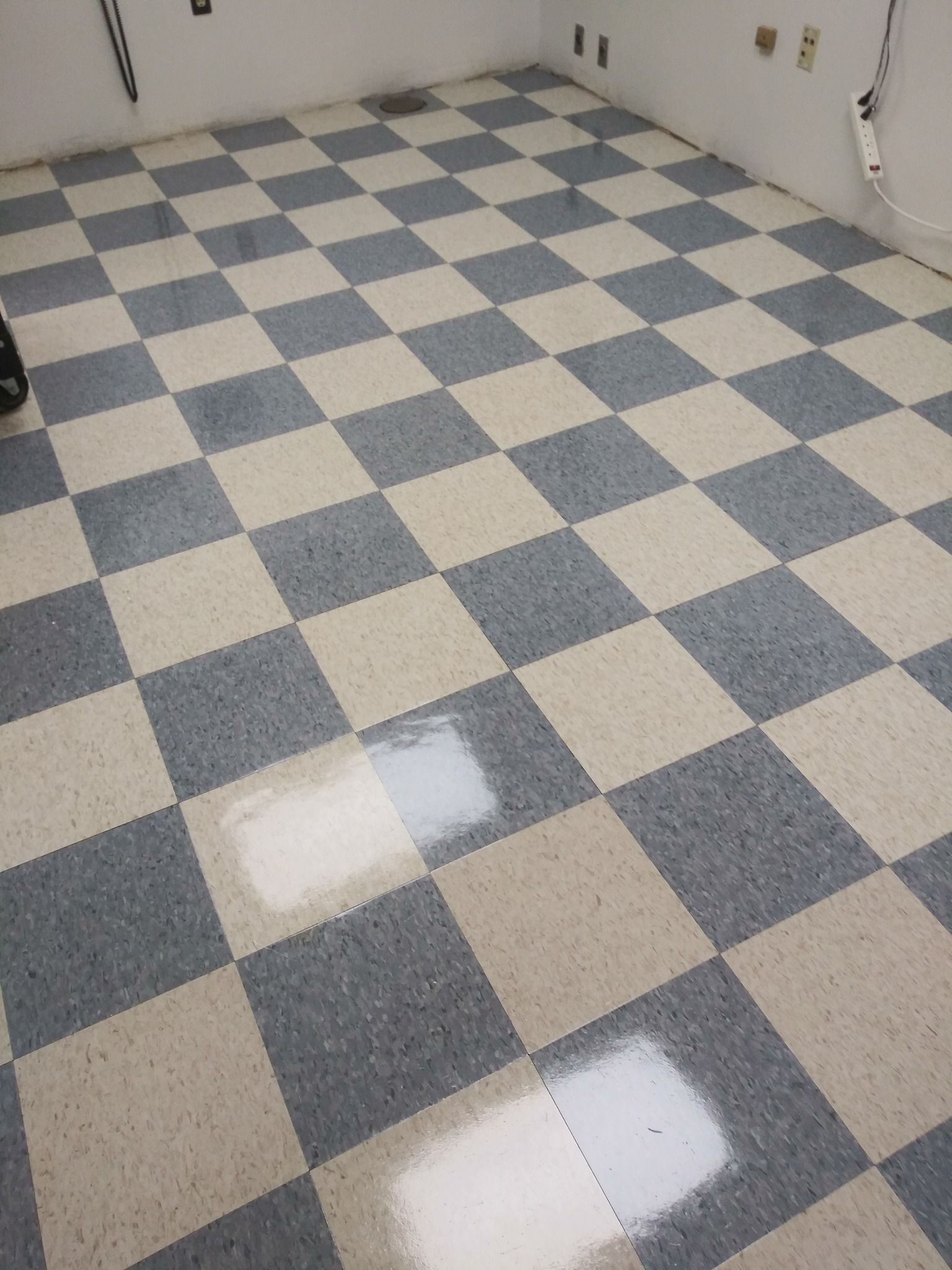 A checkered floor in a room with a light shining on it