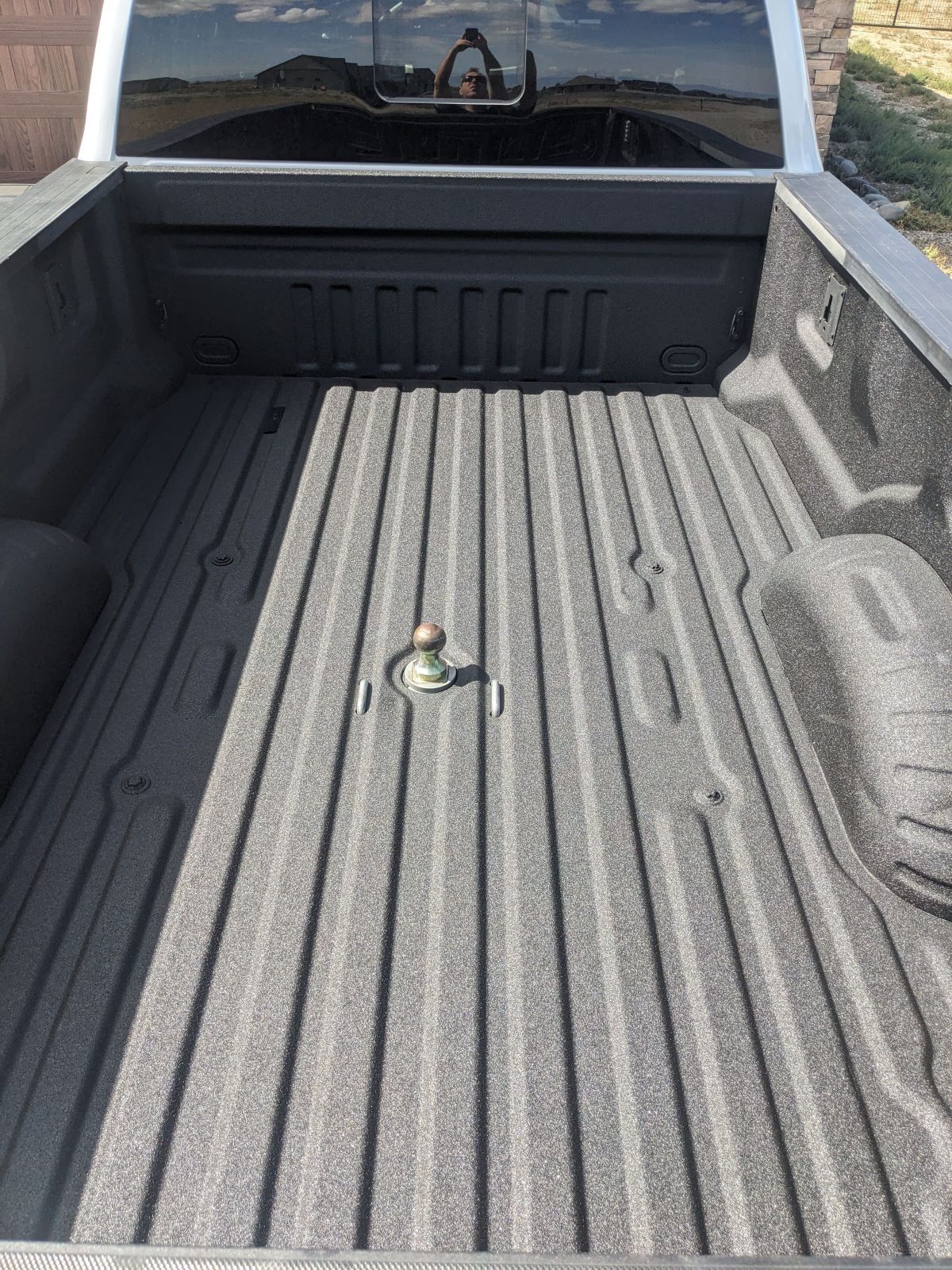 Truck bed with a gooseneck hitch, coated in black bedliner.