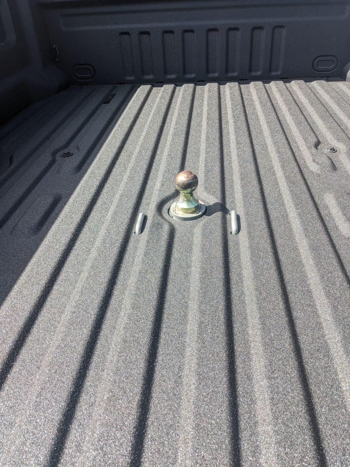 Black truck bed with a gooseneck hitch.