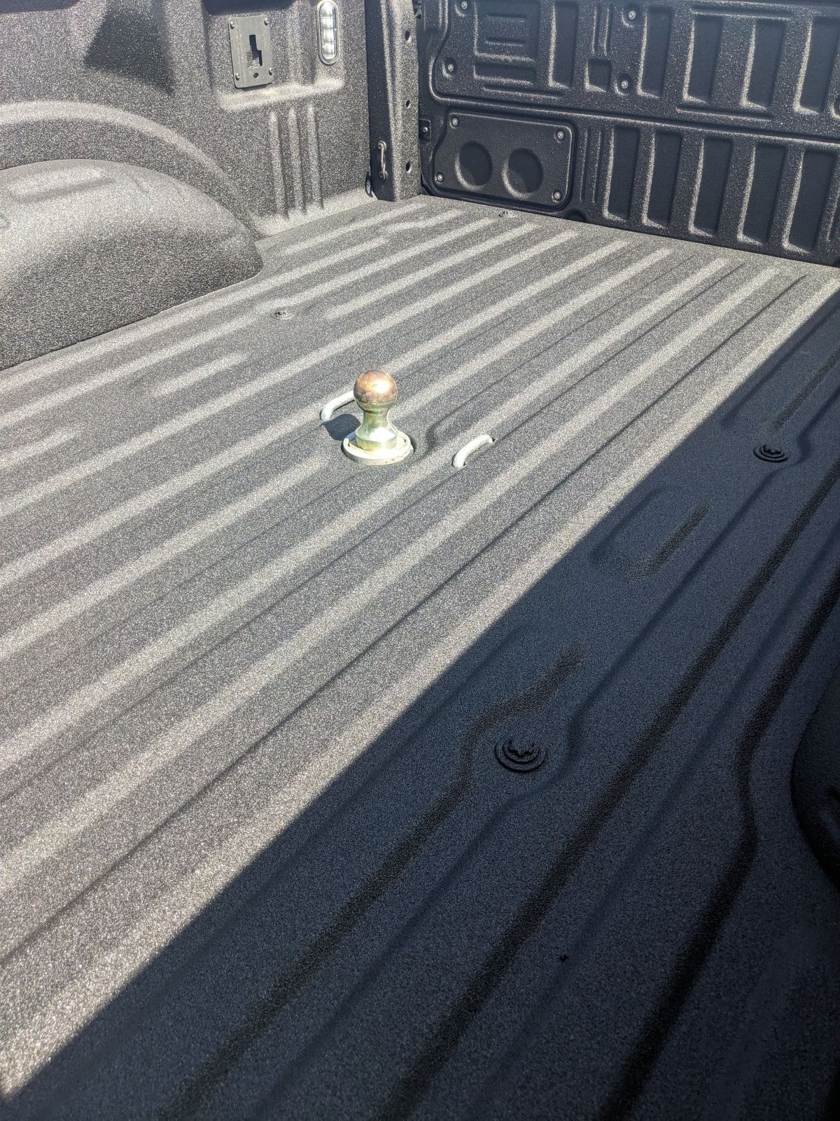 Pickup truck bed with a gooseneck hitch installed.