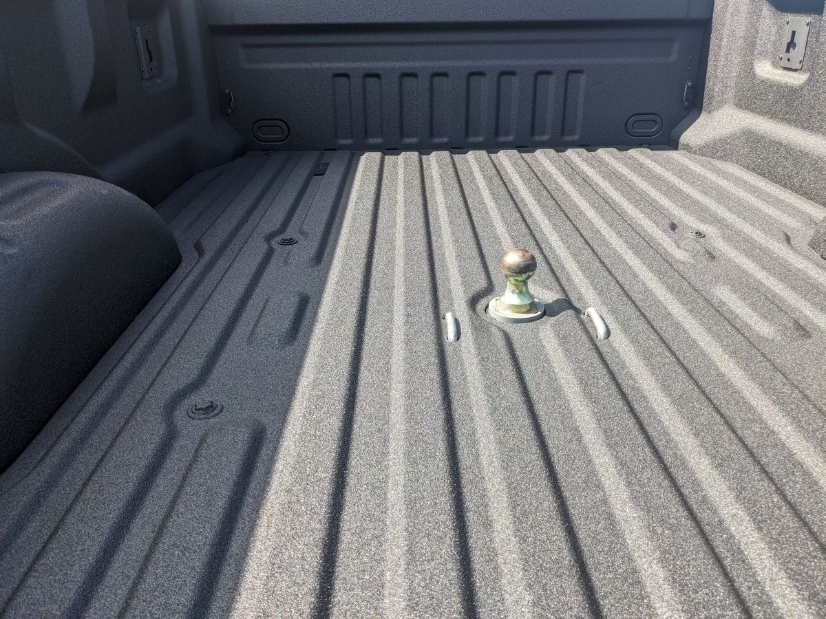 Truck bed with spray-on bed liner and a gooseneck hitch.