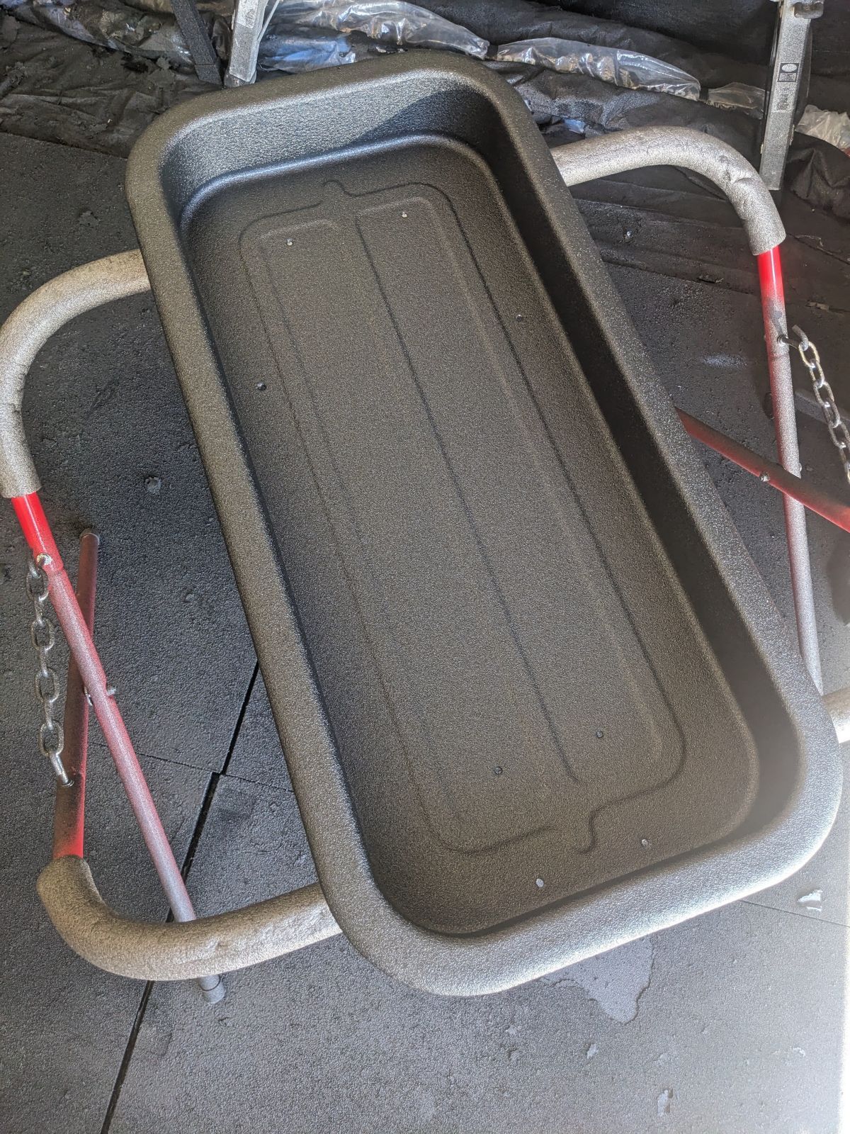 Gray rectangular tray on a metal stand with red accents.