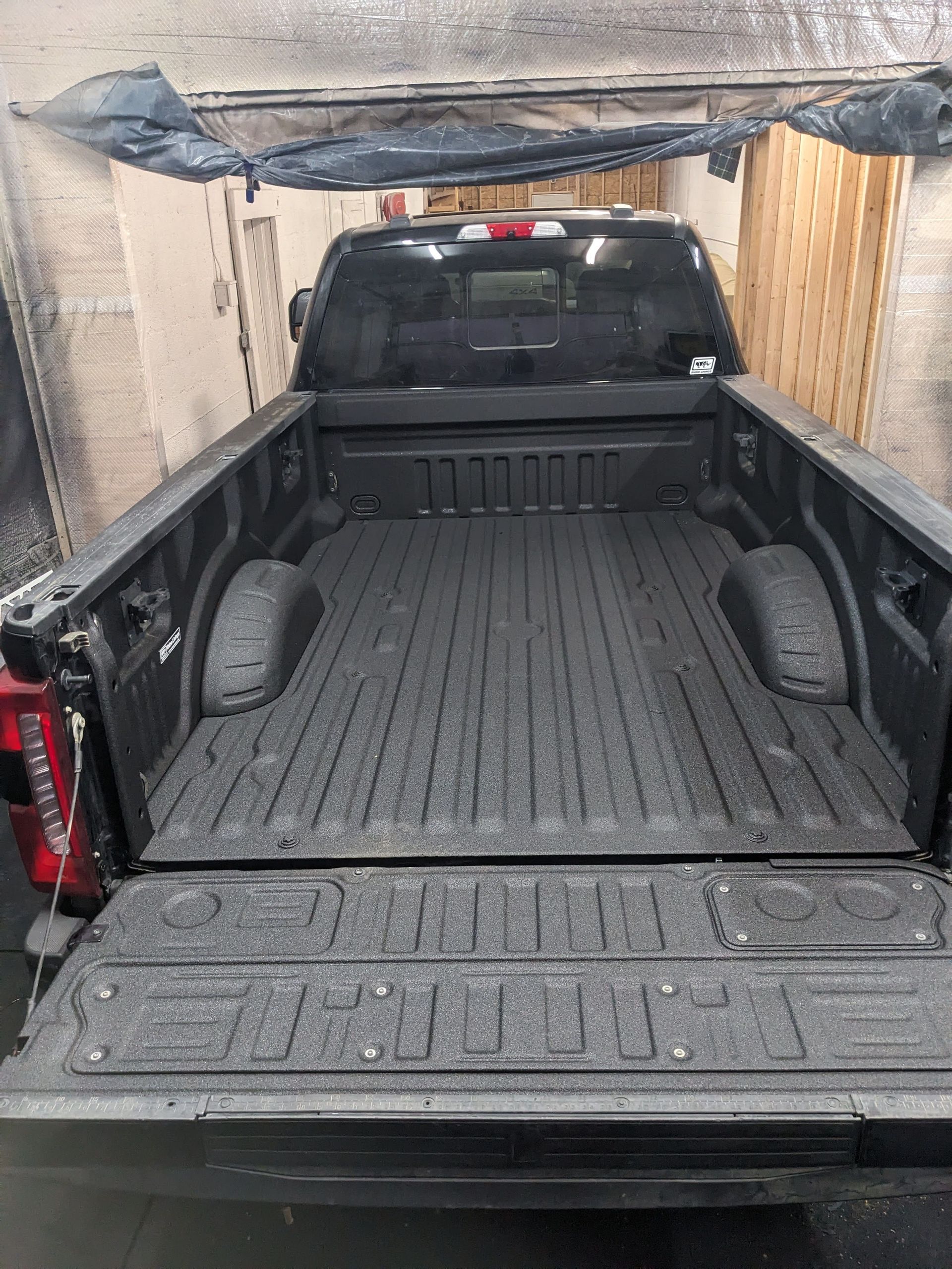 Black pickup truck bed with textured coating.