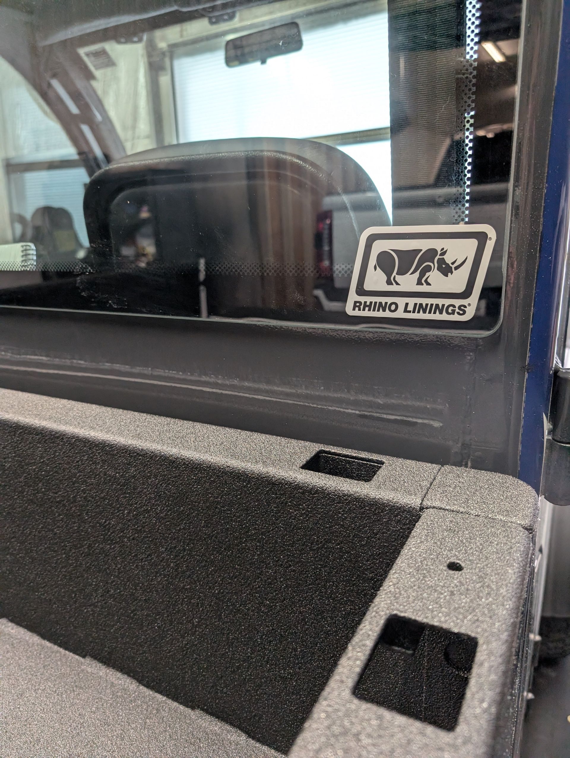 Black truck bed with a sticker that says 