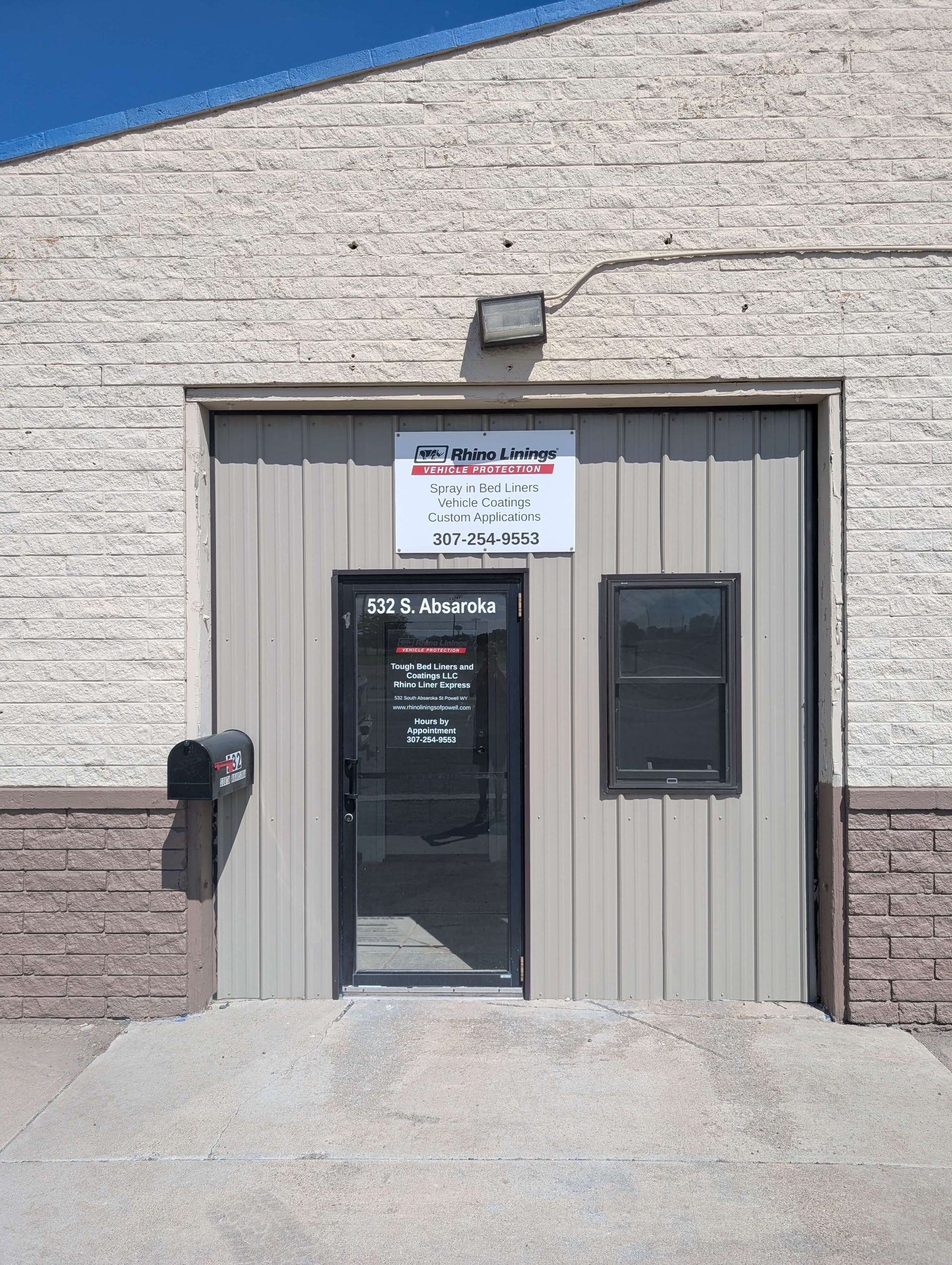 Exterior of an auto repair shop with a sign above the door.