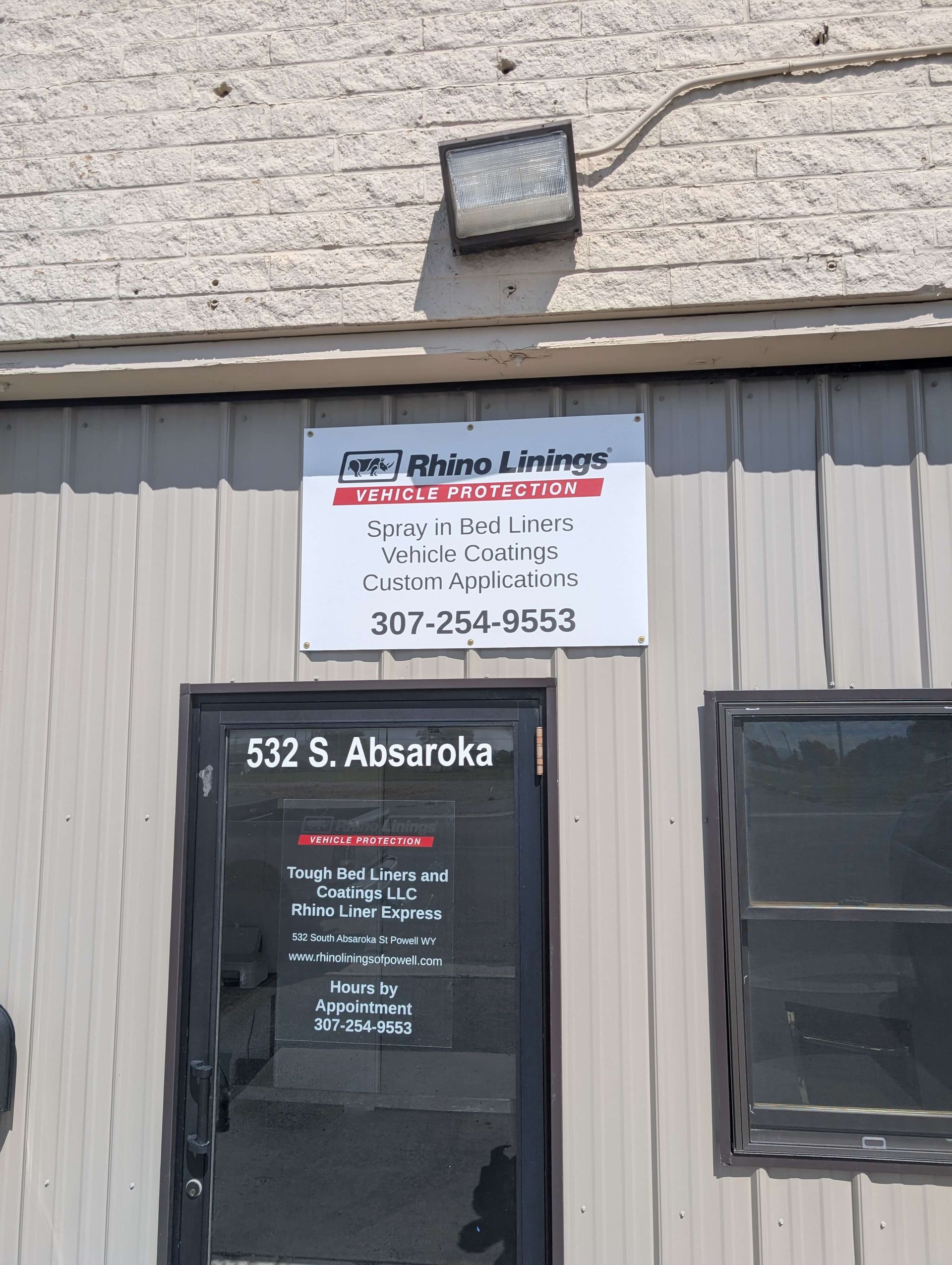 Sign for Rhino & Rhino, located at 532 S. Absaroka, with a lit flood light above the door.