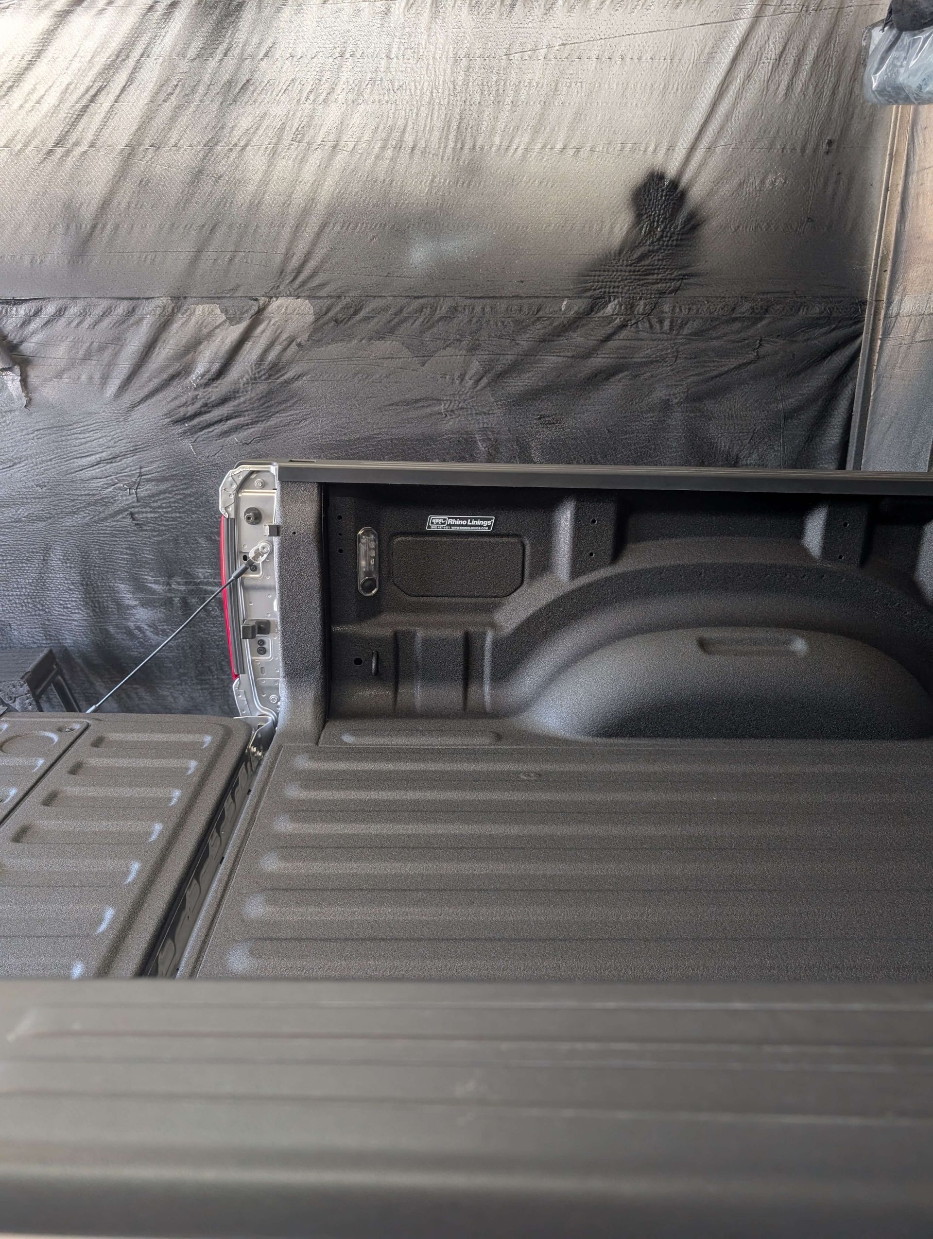 Truck bed with black bedliner. Tailgate and rear cab are visible.