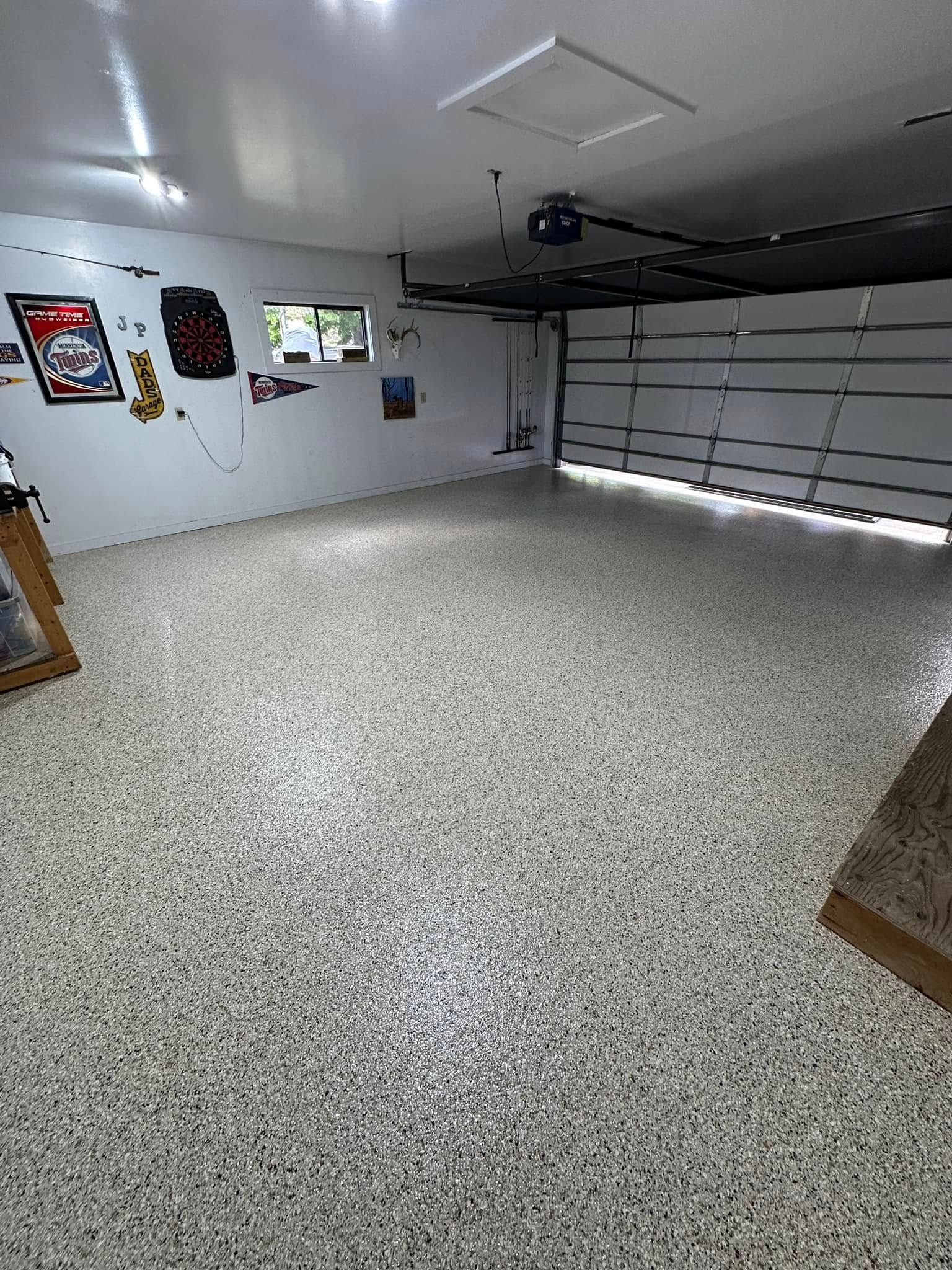 Finished garage with speckled flooring, white walls, and a closed garage door.