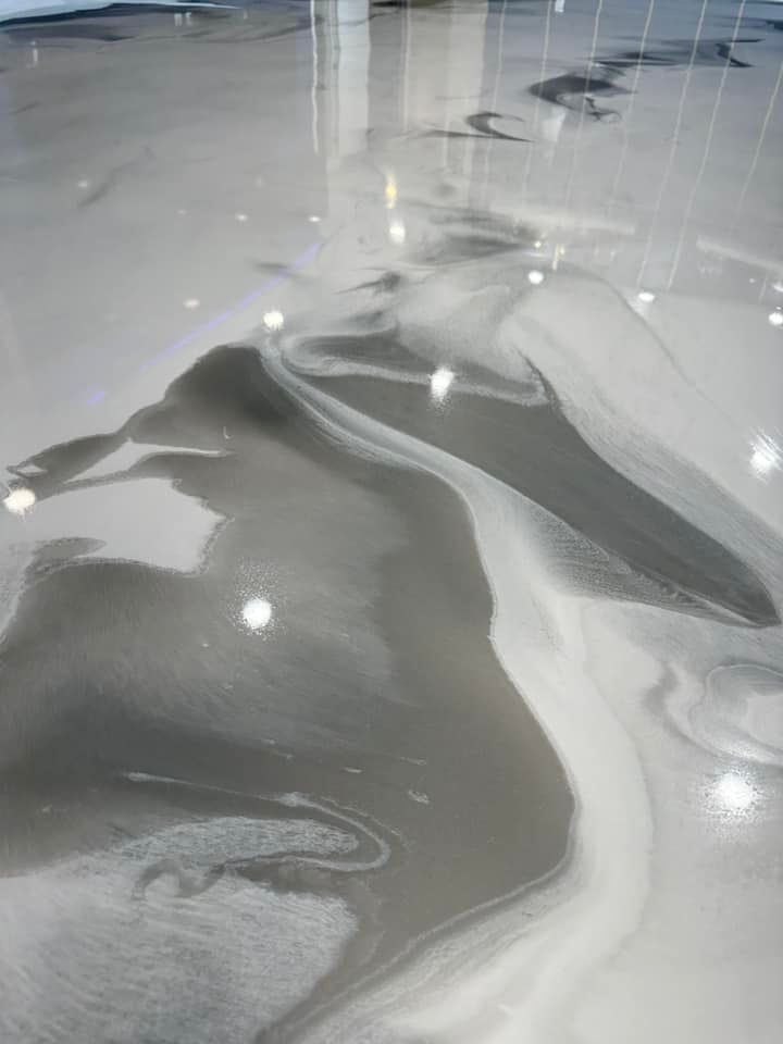 Swirled, glossy epoxy floor in shades of gray and white.
