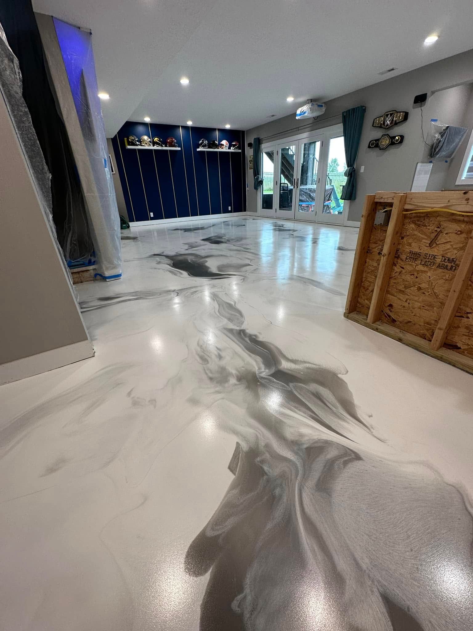 Shiny, marbled-look floor in a room with blue accent wall and open doors to the outside. Pallet visible on the right.
