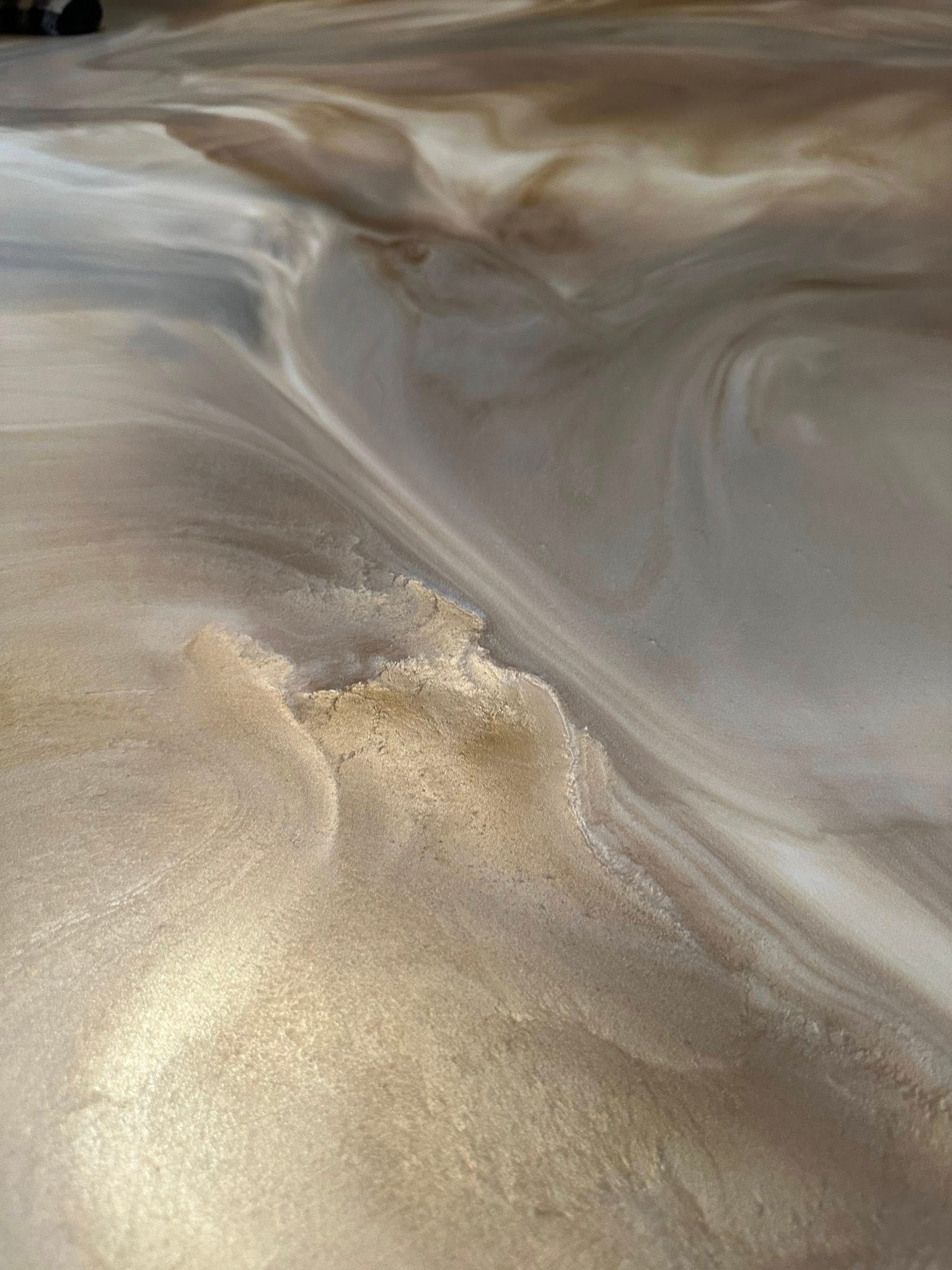 Metallic gold and silver epoxy flooring with swirling patterns and textural variations.