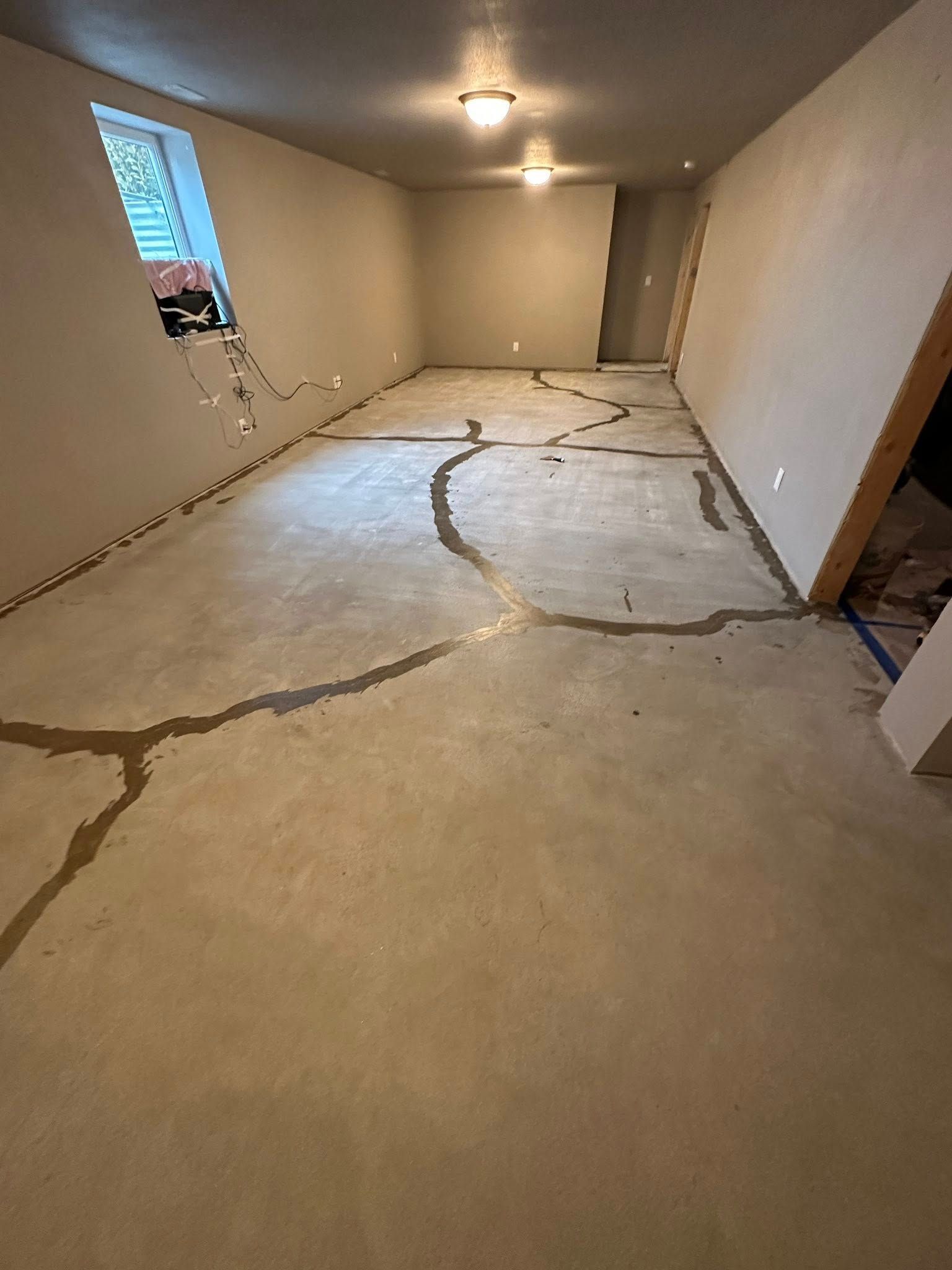 Concrete room with cracks in the floor and unfinished walls.