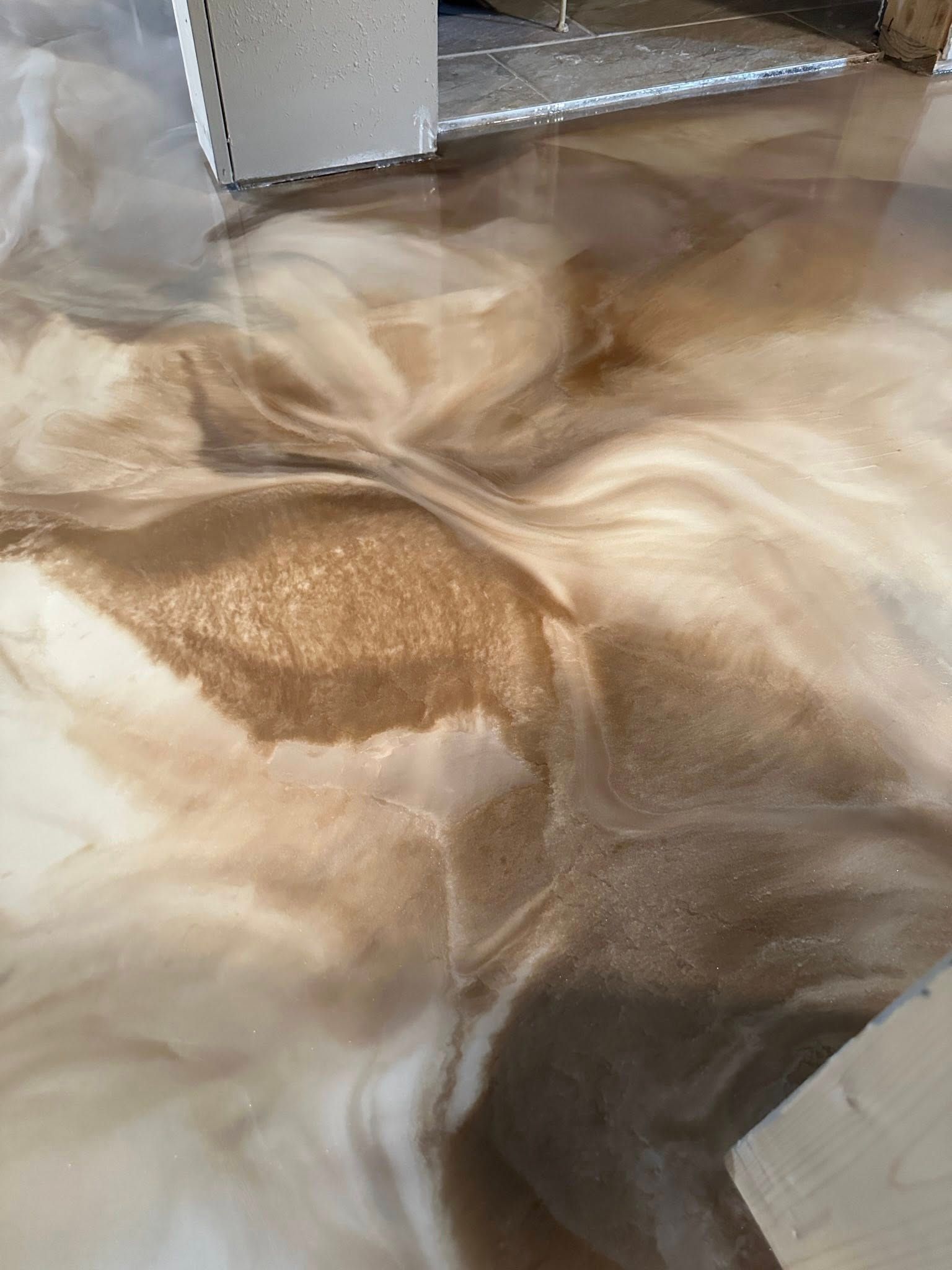 Metallic epoxy floor with swirled brown and cream hues.