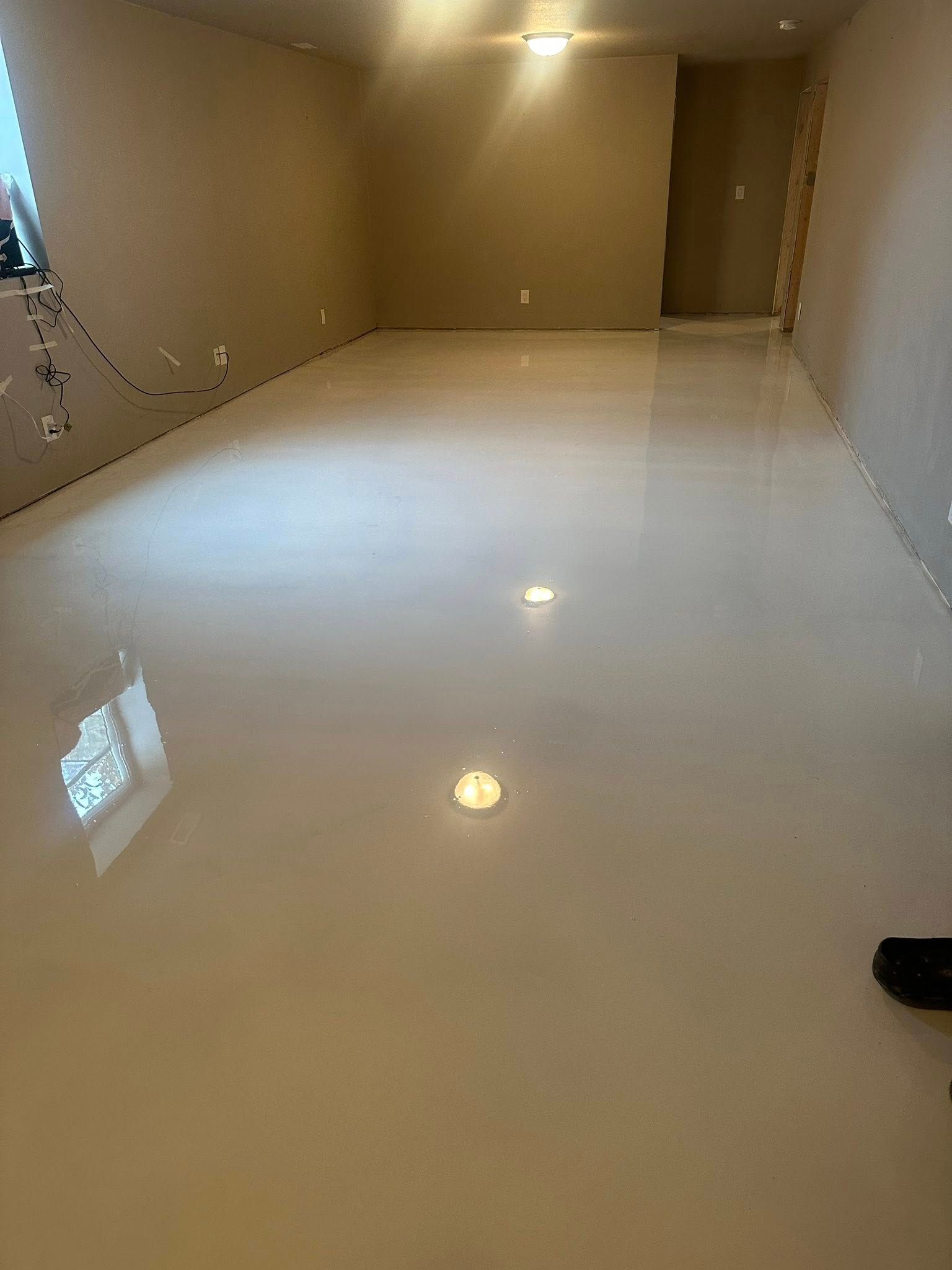 A room with a light-colored, glossy epoxy floor. The walls are a neutral beige.