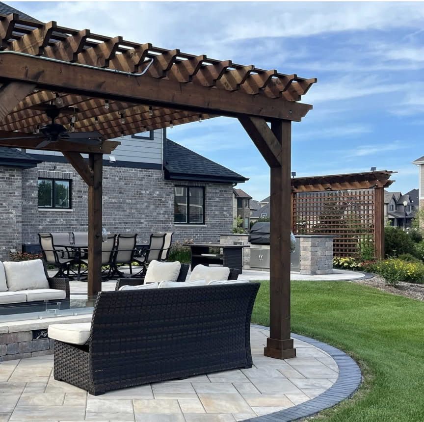 A patio with a couch and chairs under a pergola
