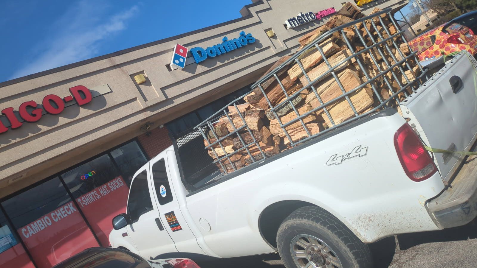 A white truck is parked in front of a domino 's pizza restaurant