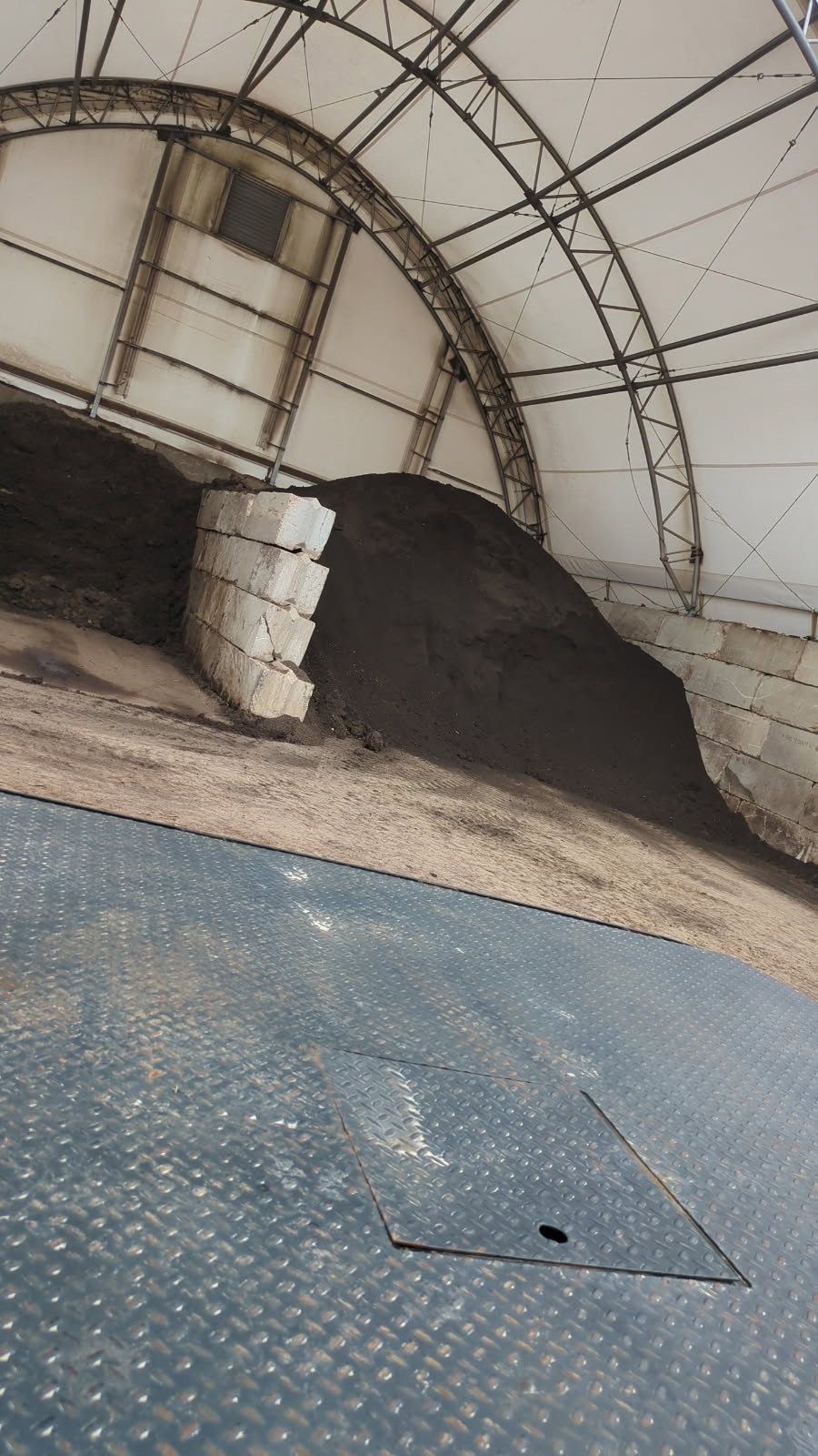 A large pile of dirt is sitting inside of a building.