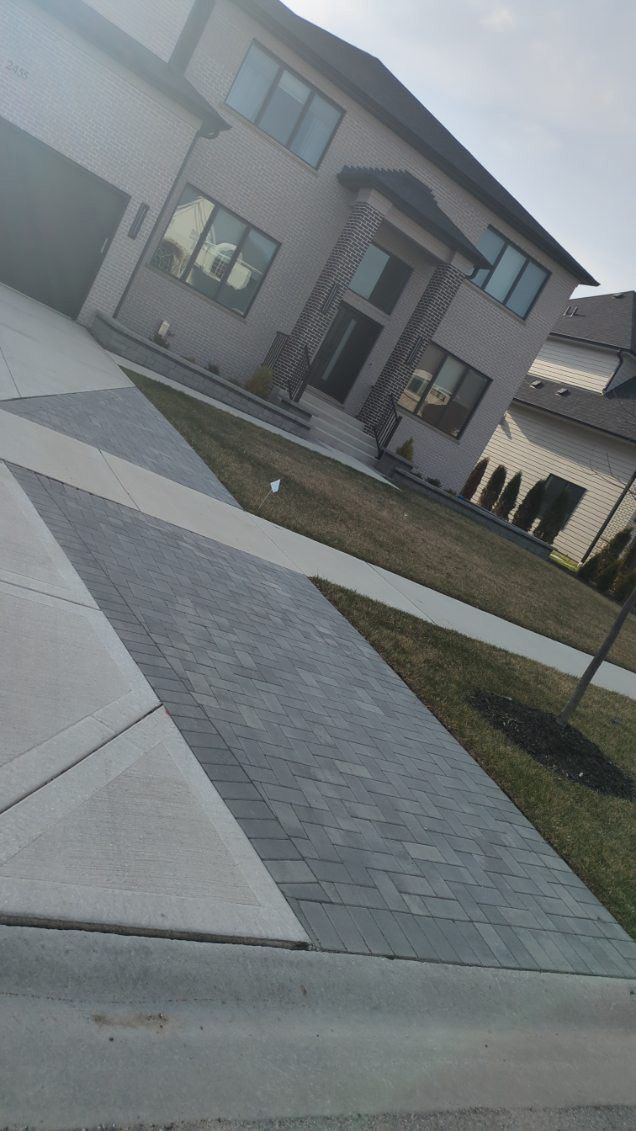 A large house with a driveway and a sidewalk in front of it.